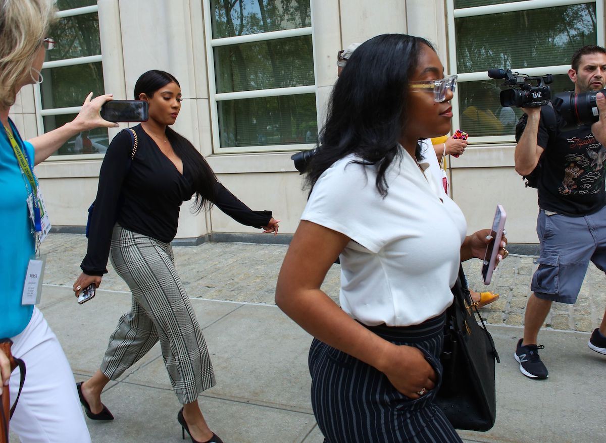 R. Kelly's ex-girlfriend Azriel Clary walking on the sidewalk surrounded by photographers.
