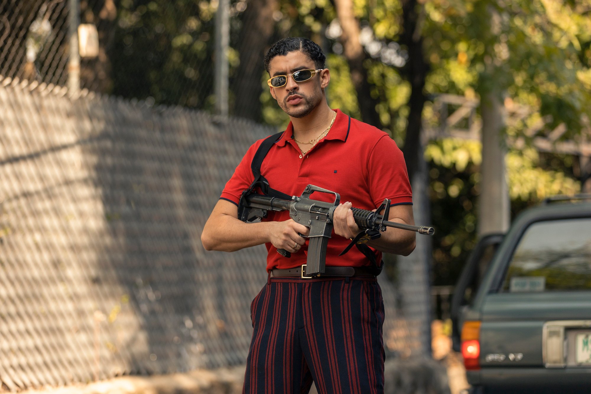 Bad Bunny holding a machine gun in 'Narcos: Mexico' Season 3.