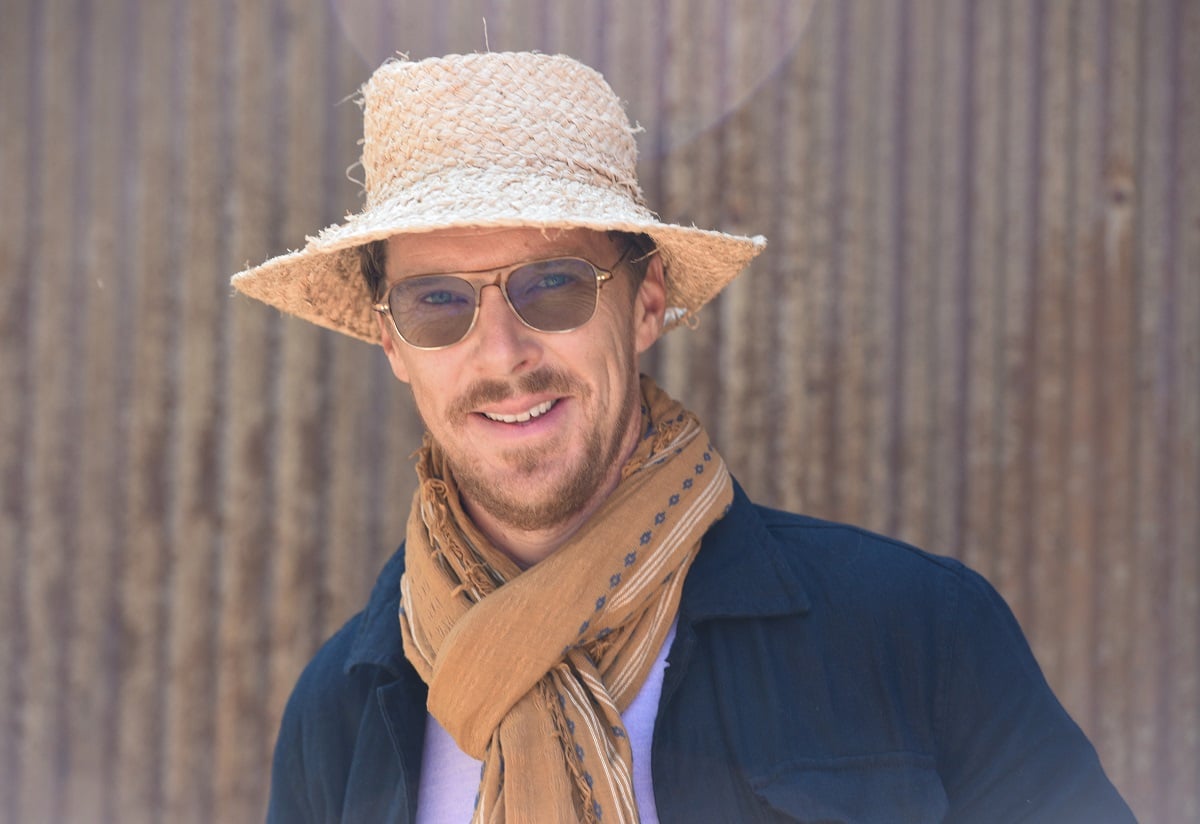 Benedict Cumberbatch smiling in a hat and sunglasses