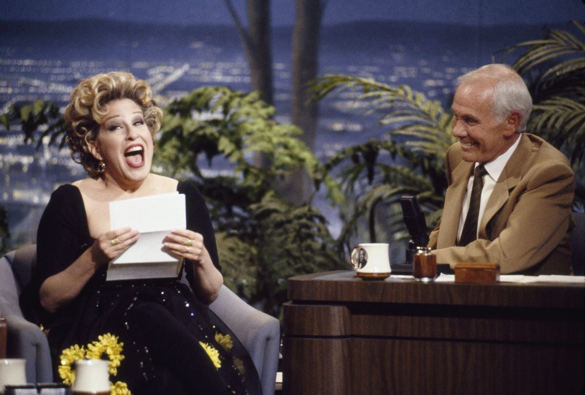 Bette Midler holding a piece of paper during an interview with host Johnny Carson 