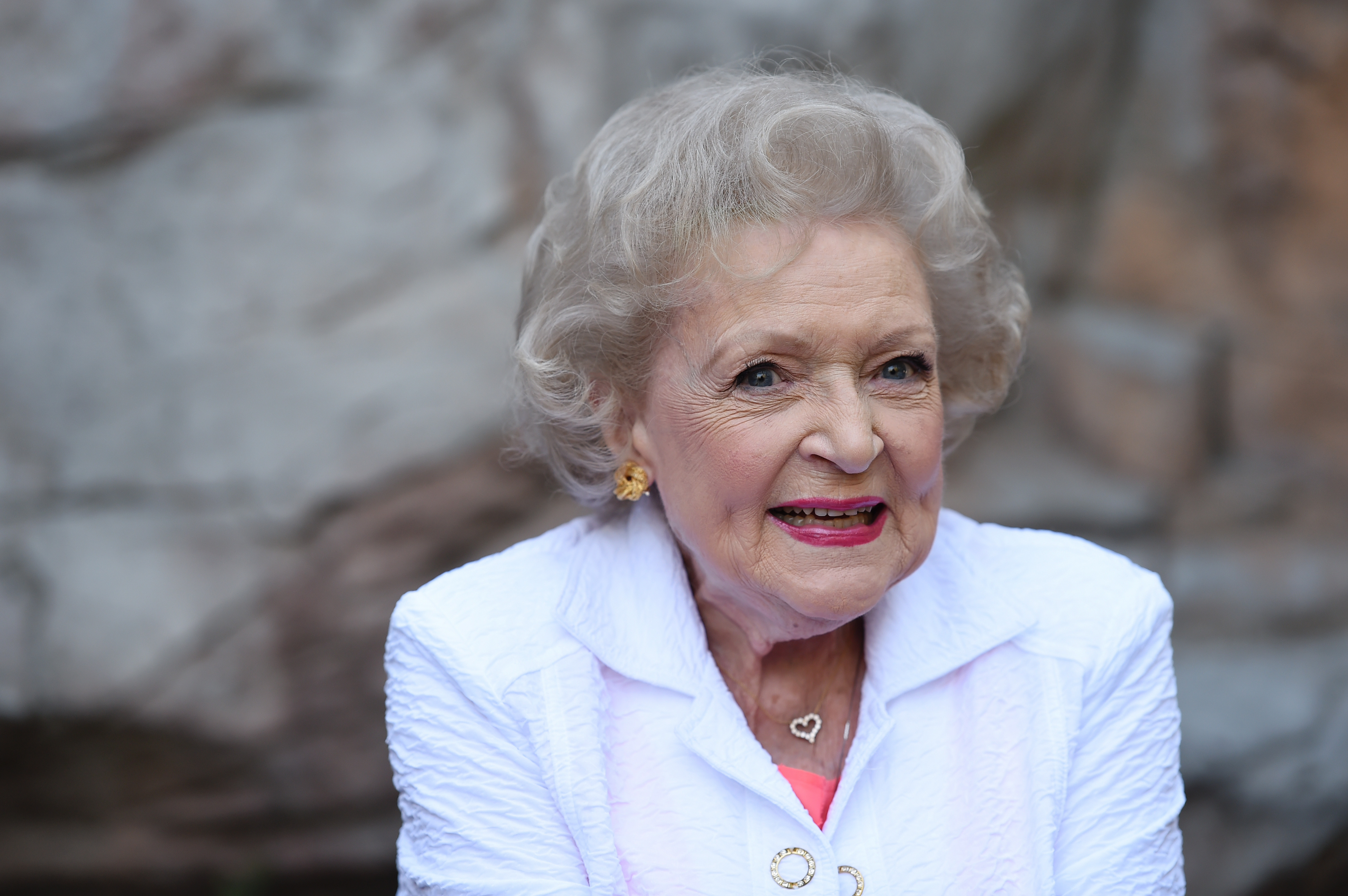 Betty White poses in a white jacket