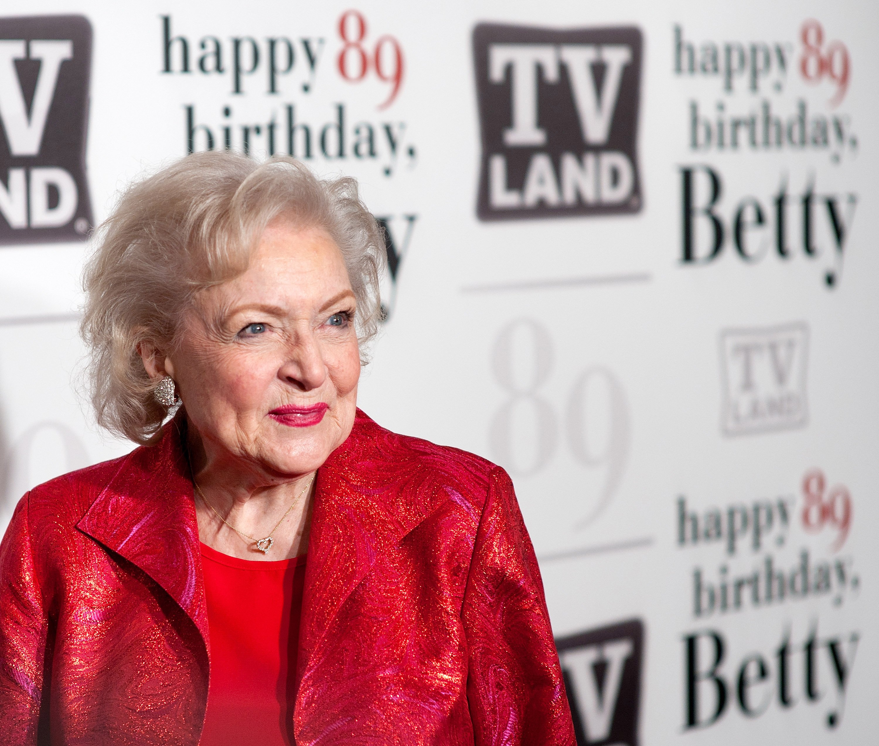 Betty White wears a red outfit during a media event