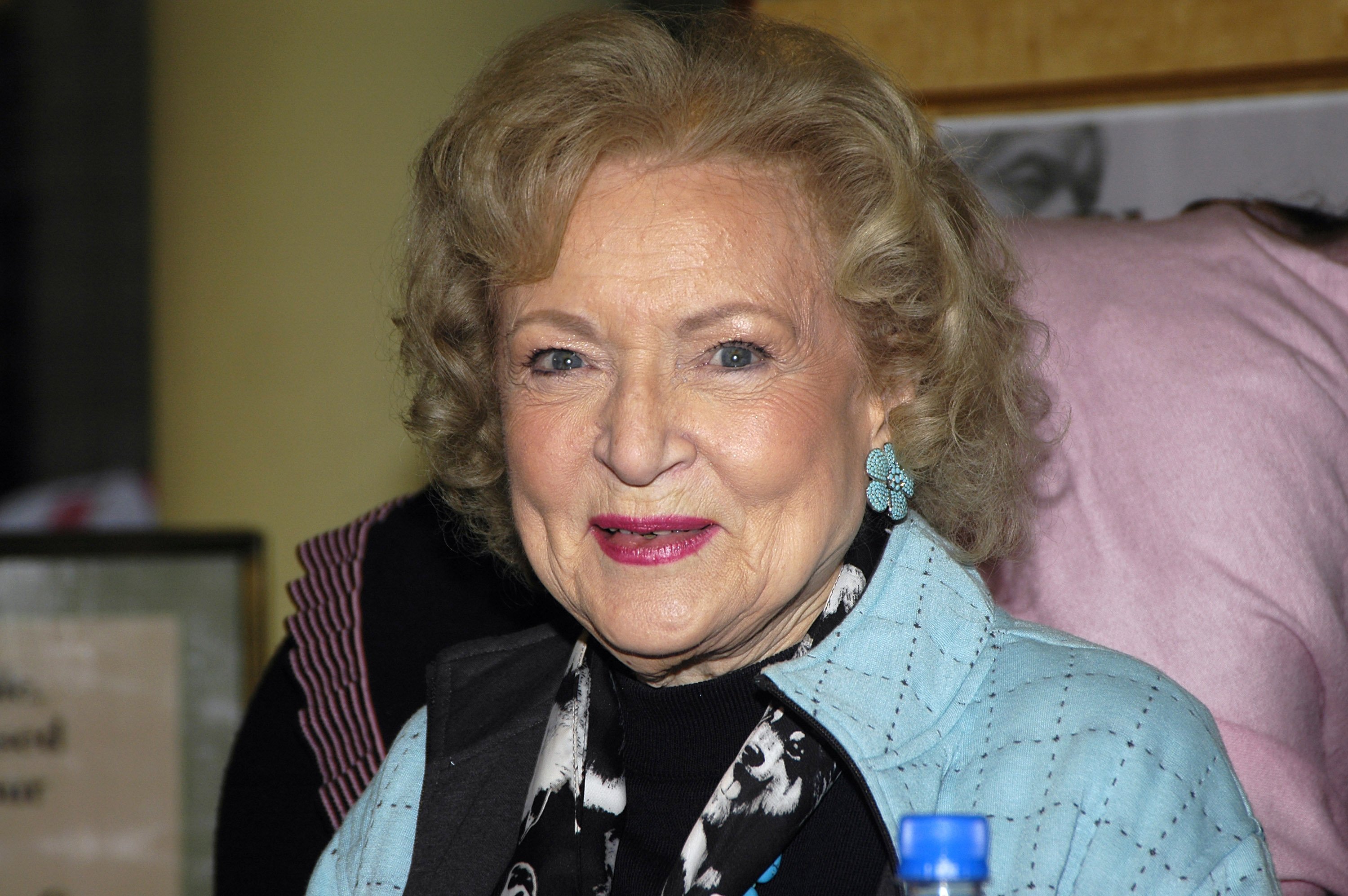 Betty White smiles while wearing a powder blue jacket.