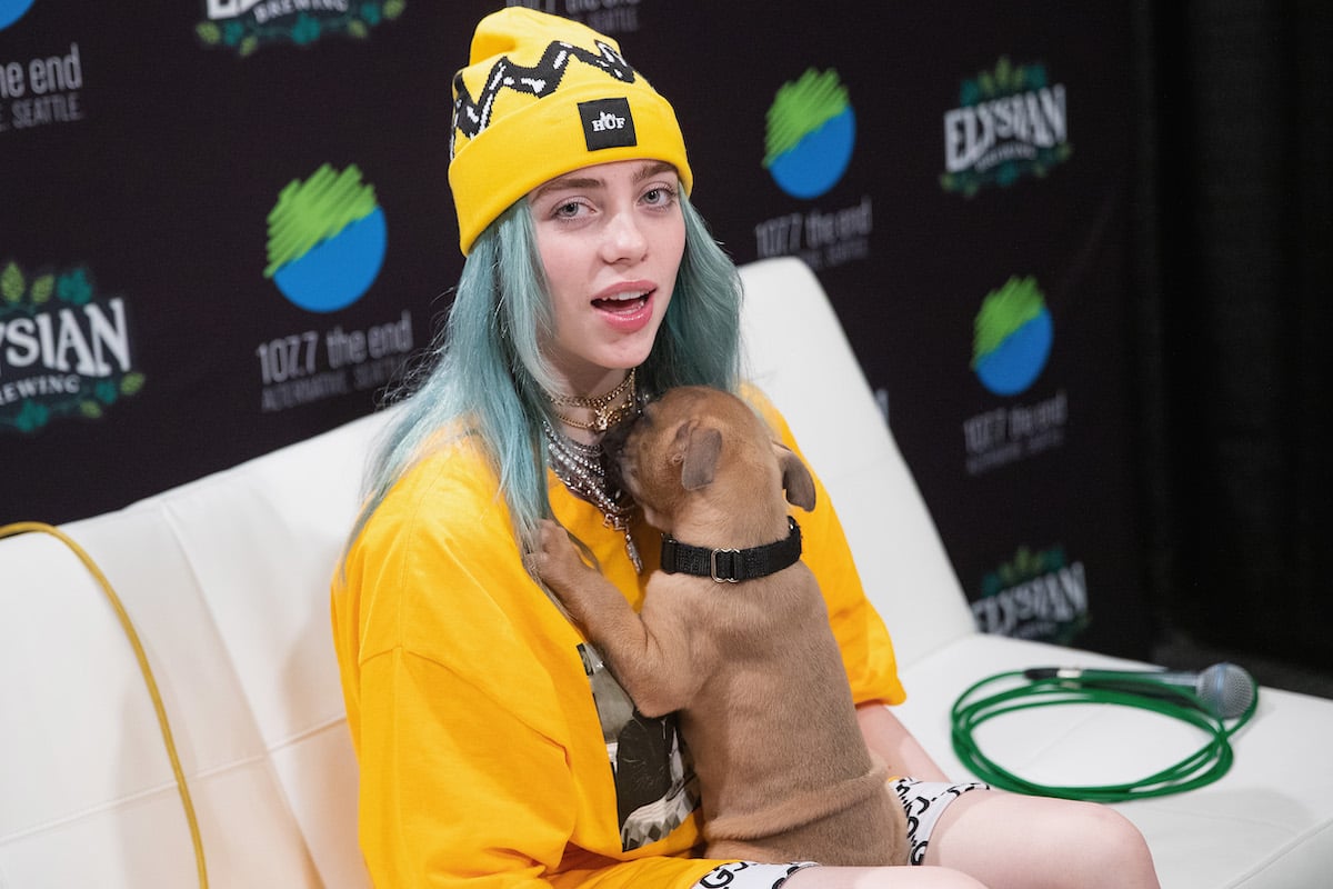 Billie Eilish plays with a puppy.