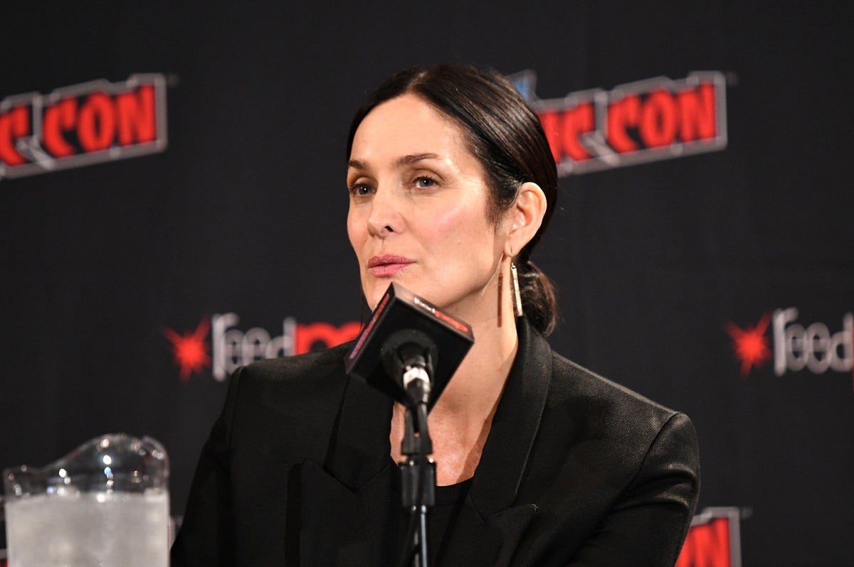 Carrie-Anne Moss speaking into a microphone