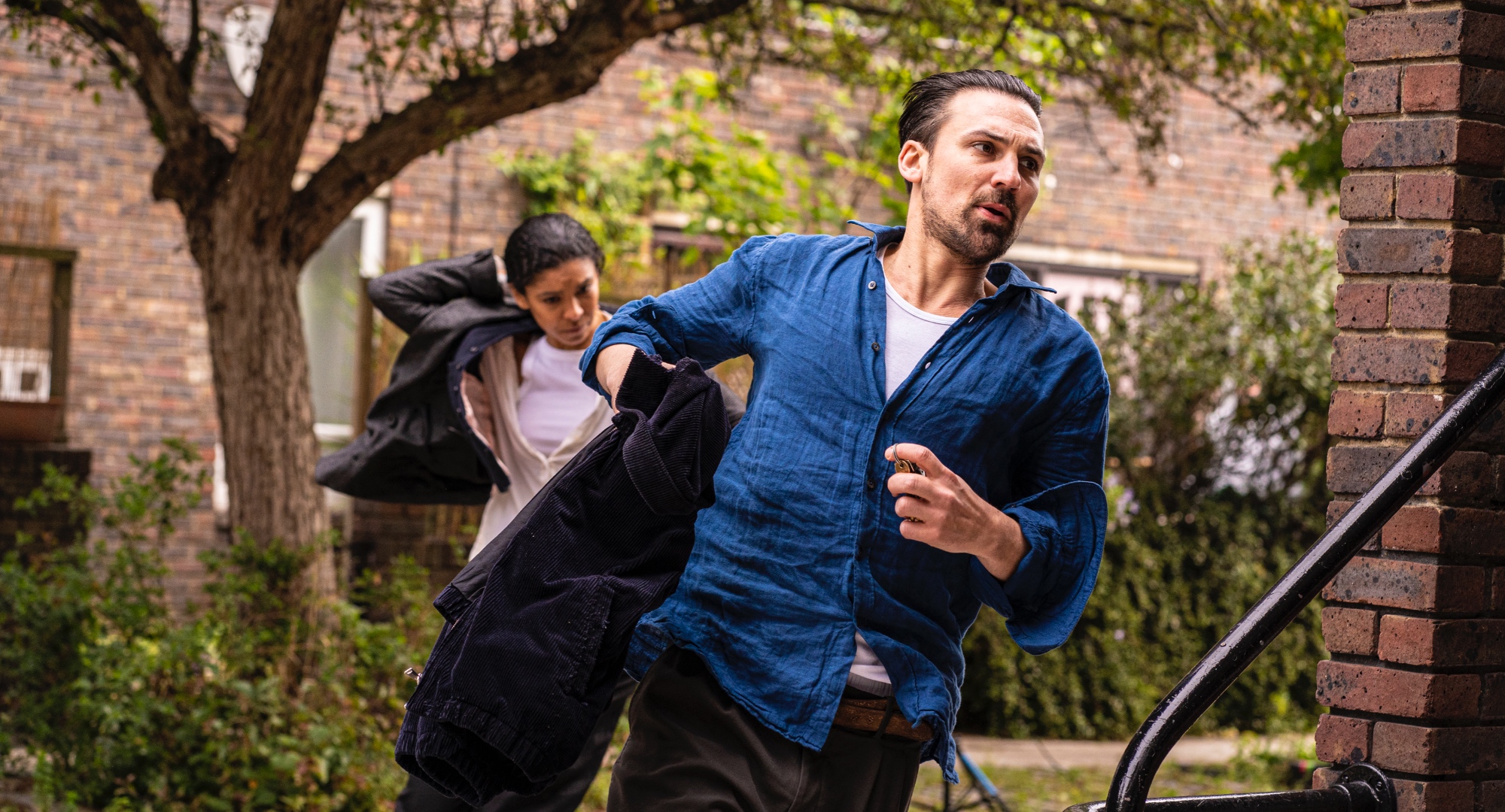 Characters Emily Baxter and Nathan Rose in episode 2 still for 'Ragdoll' running through backyard.