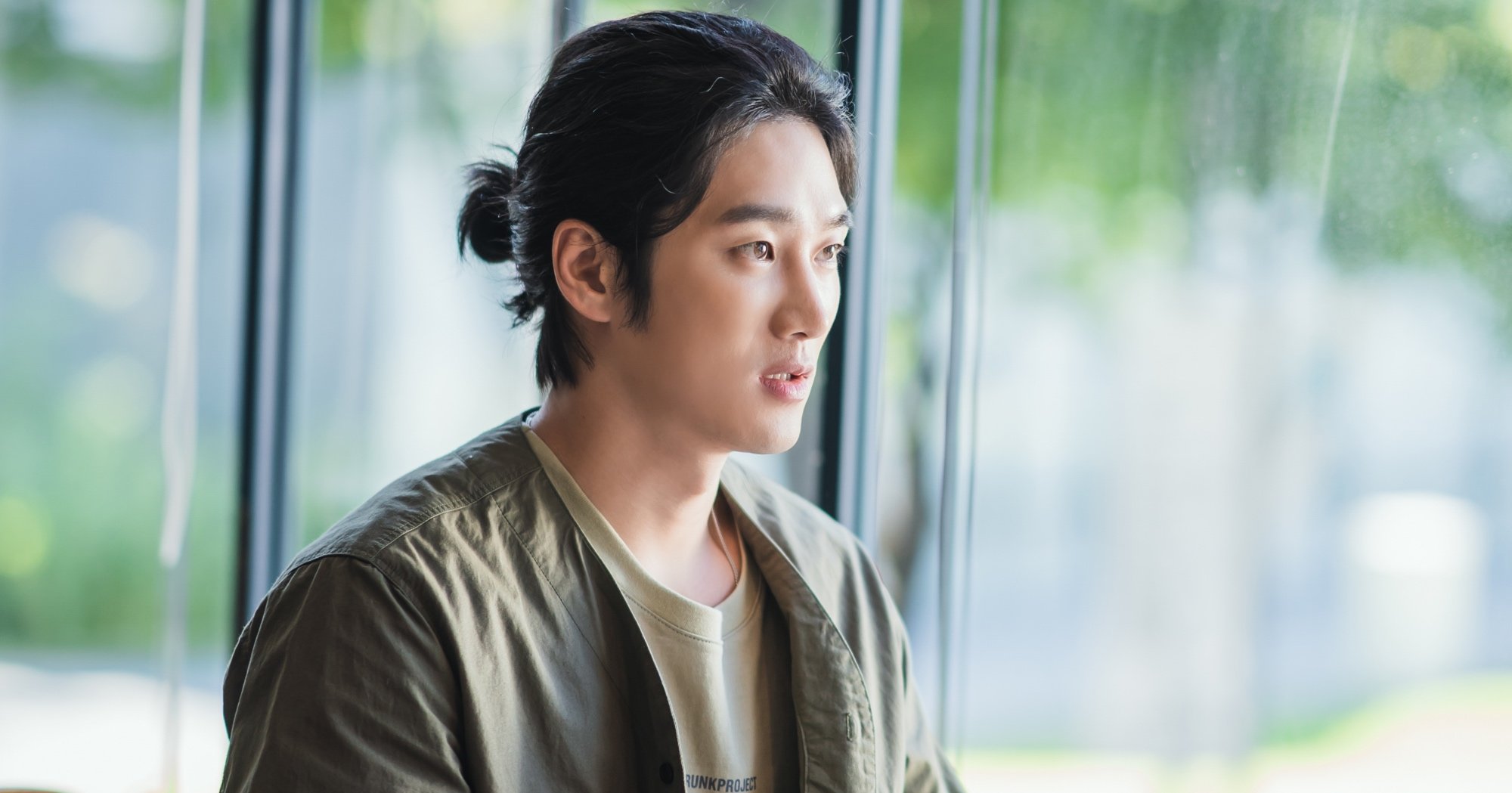 Character Goo Woong from 'Yumi's Cells' Episode 14 breakup wearing green shirt and tied up hair.