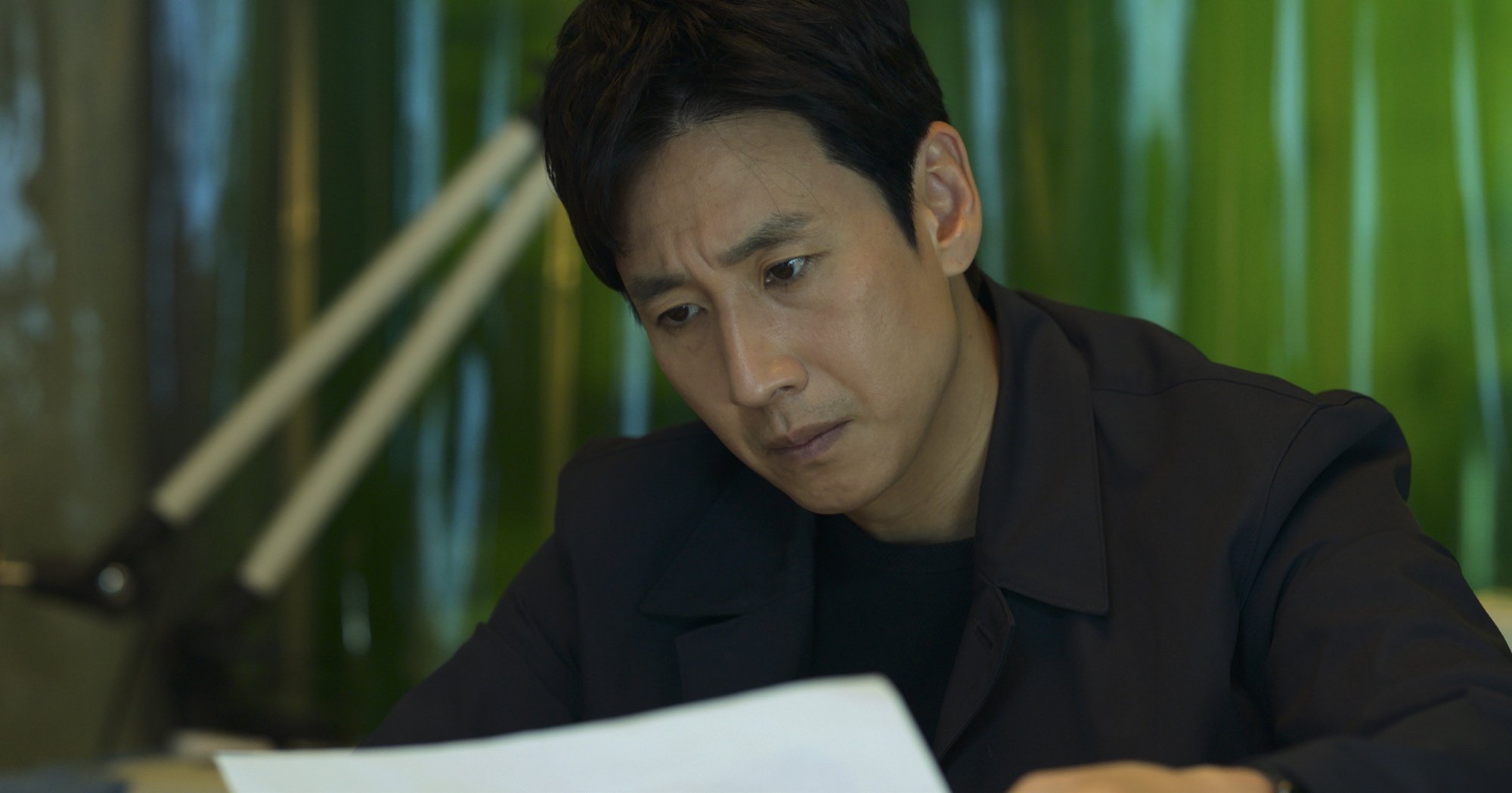 Character Koh Sewon from 'Dr. Brain' Episode 4 looking at a piece of paper.