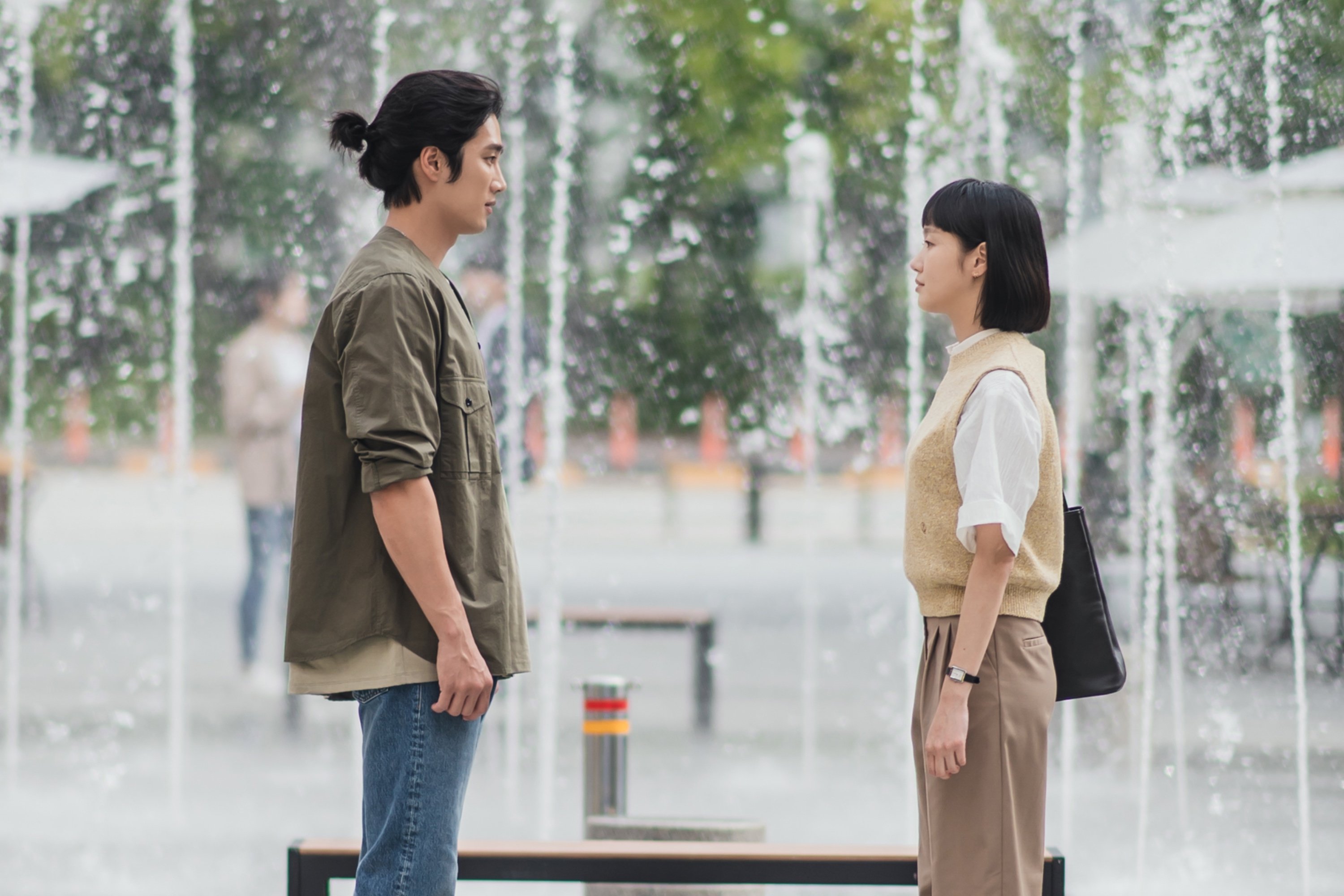Characters Goo Woong and Kim Yu-mi for 'Yumi's Cells' finale standing in front of fountain.