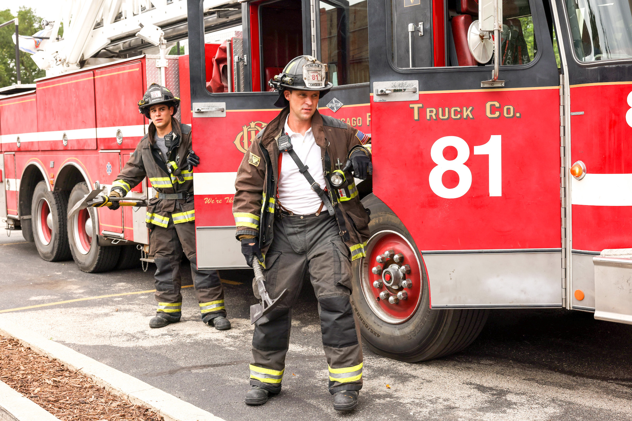 Alberto Rosende as Blake Gallo and Jesse Spencer as Matthew Casey in walking outside of a firetruck while in firefighting gear in 'Chicago Fire' Season 10