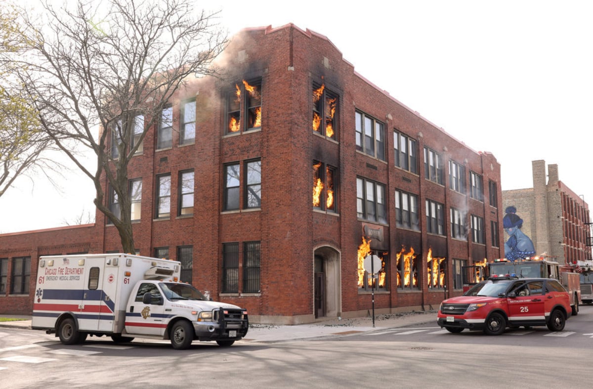 A scene from one of the Chicago shows, 'Chicago Fire.' A building is on fire and emergency responders arrive. 