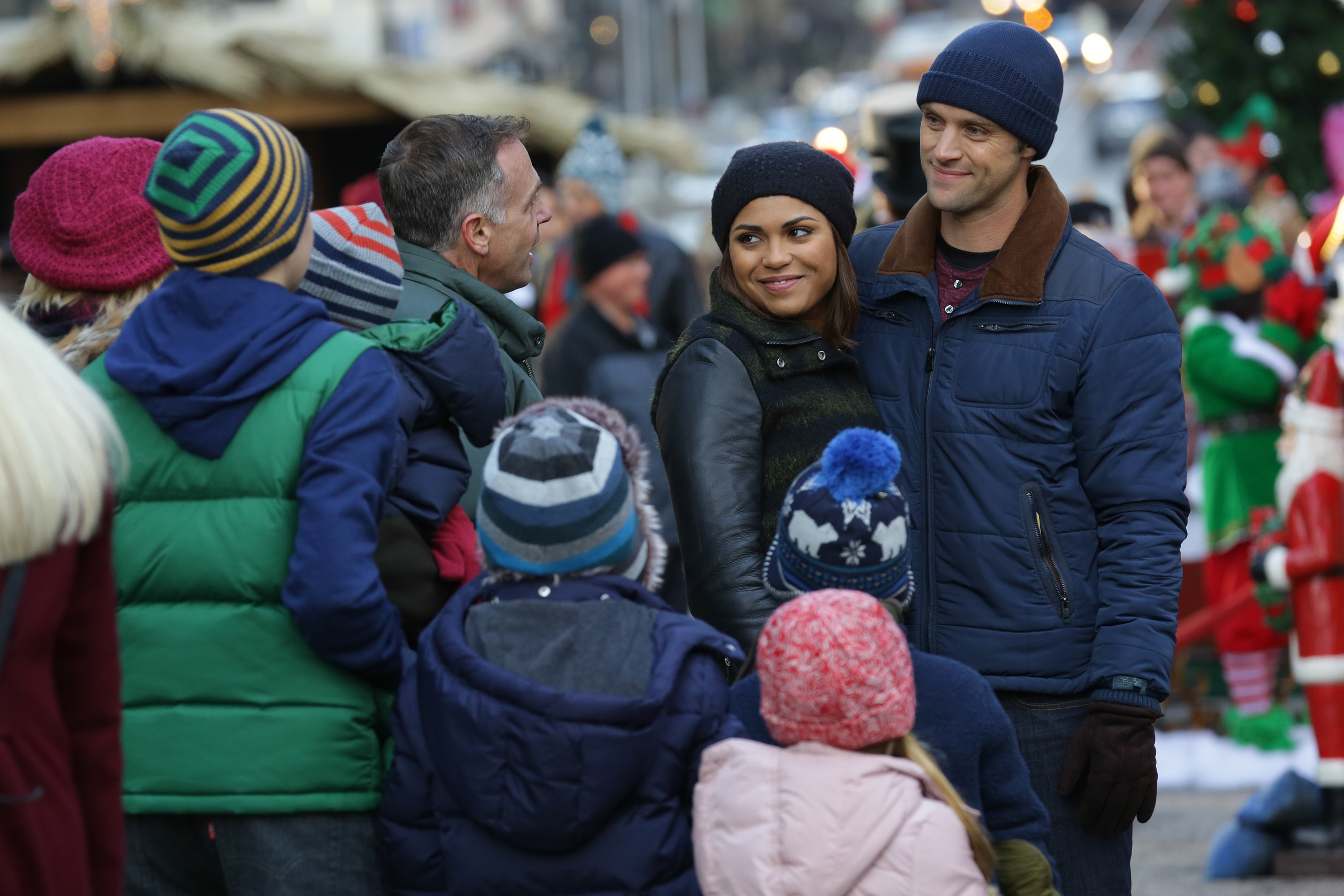 Christopher Herrmann, Gabriela Dawson, and Matthew Casey in 'Chicago Fire' Season 3. The characters are dressed warmly outdoors and smiling in a crowd.