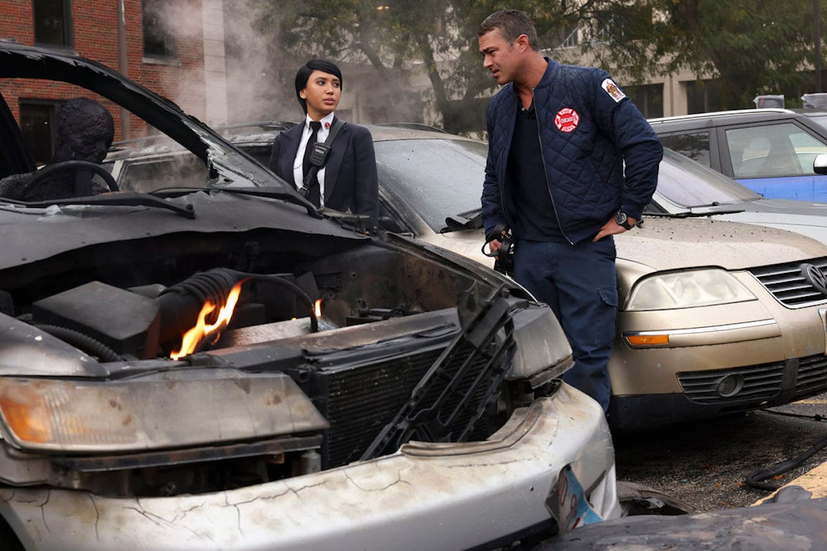 Seager and Severide standing next to a bombed out and burning car in 'Chicago Fire' Season 10 Episode 7
