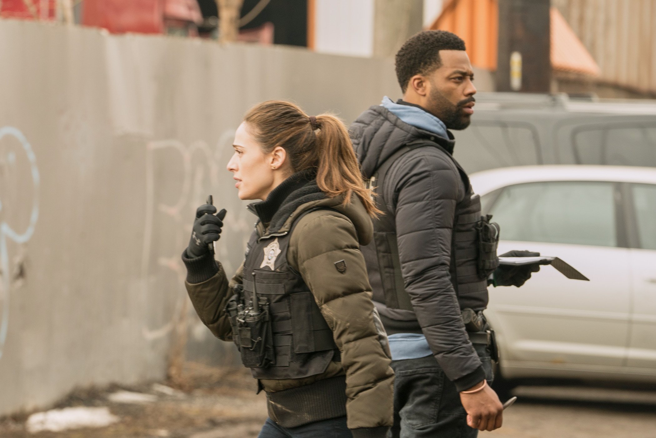 Kim Burgess and Kevin Atwater from 'Chicago P.D.' Season 9 both in uniform looking in different directions outdoors