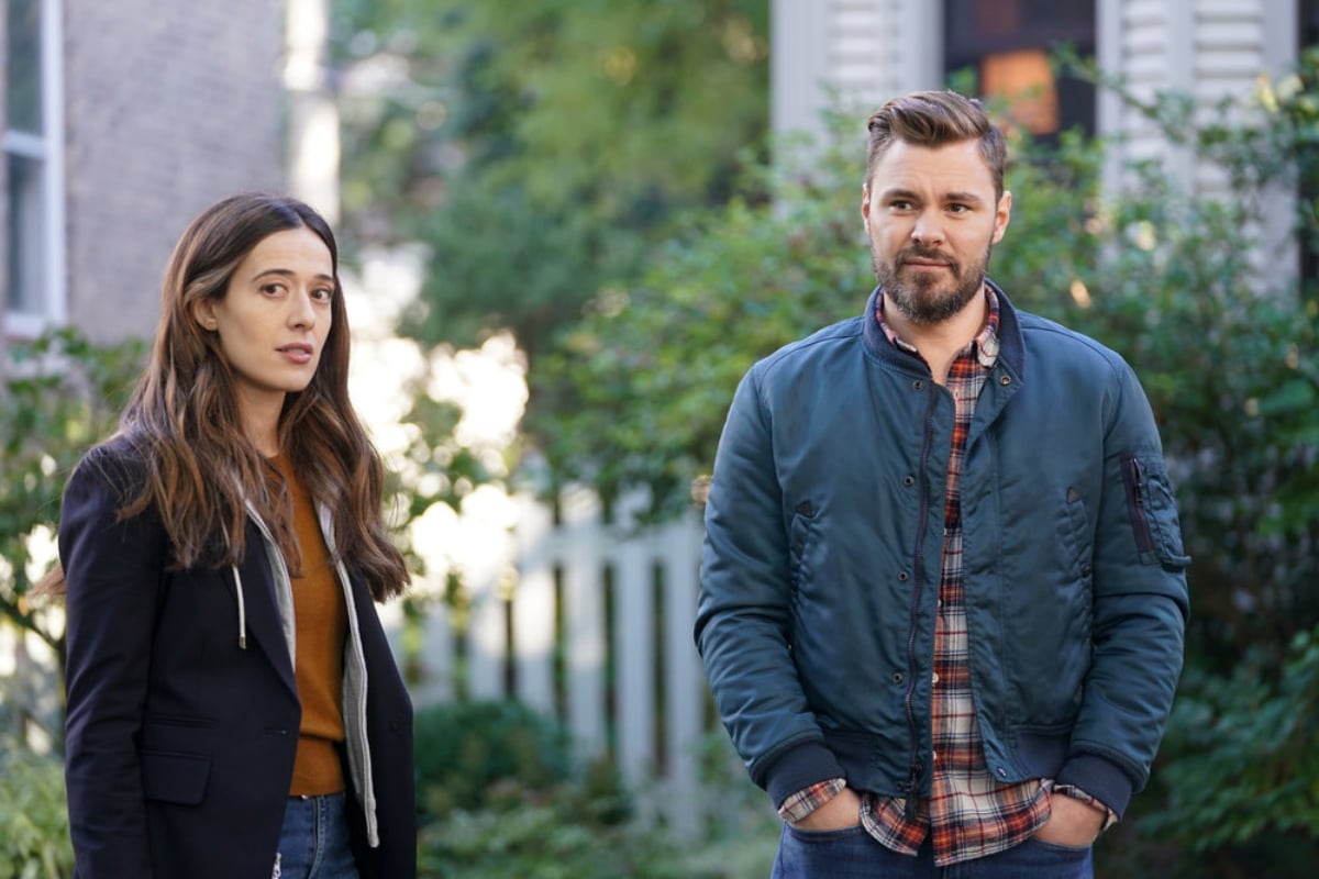 Marina Squerciati as Kim Burgess and Patrick John Flueger as Adam Ruzek in Chicago P.D. Season 9. Burgess and Ruzek stand outside.