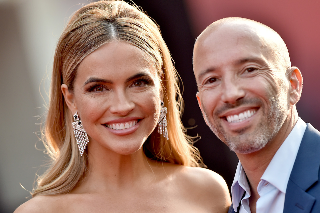 Chrishell Stause and Jason Oppenheim pose together smiling.