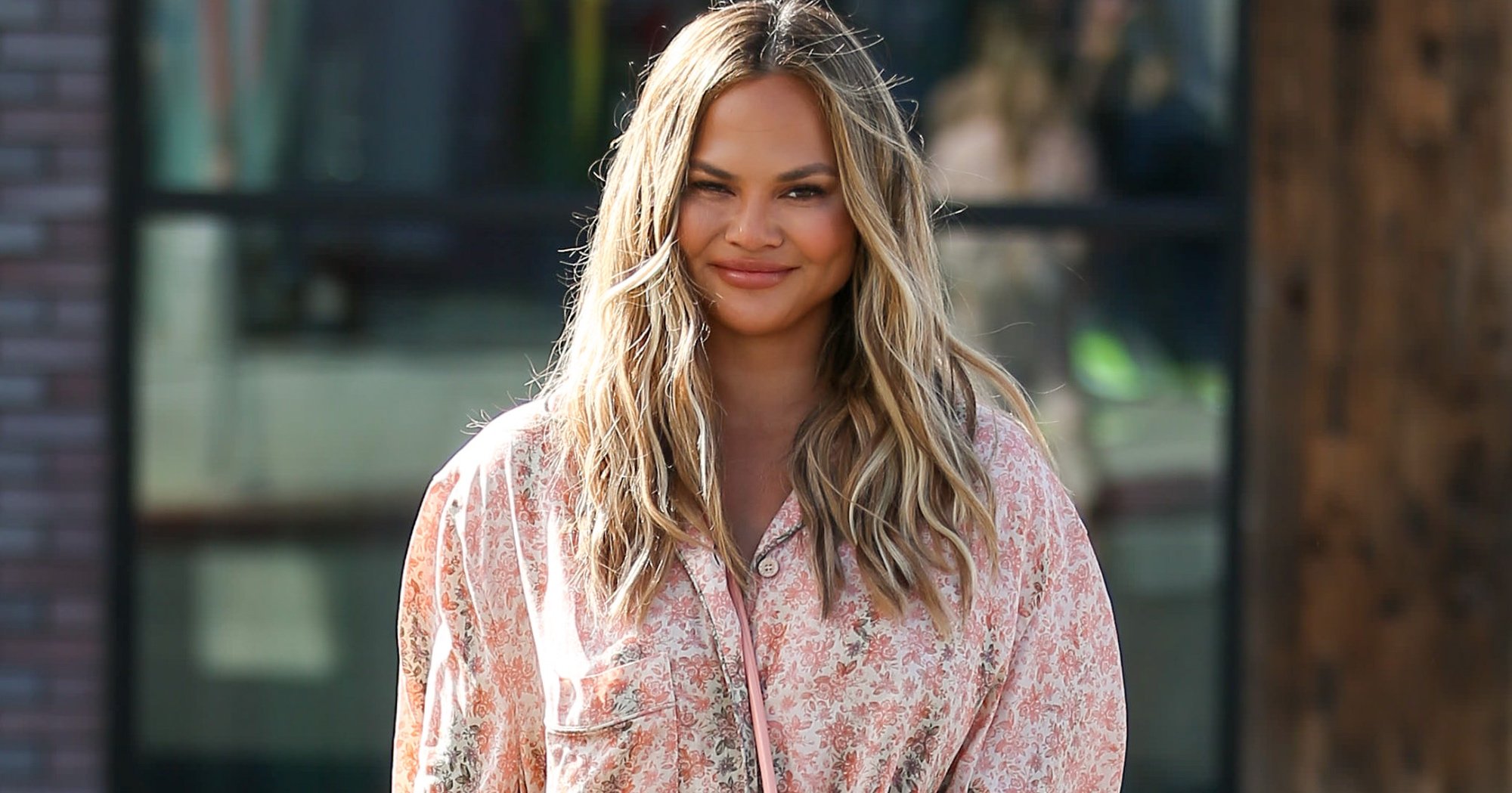 Chrissy Teigen in relation to 'Squid Game' party wearing floral blouse.