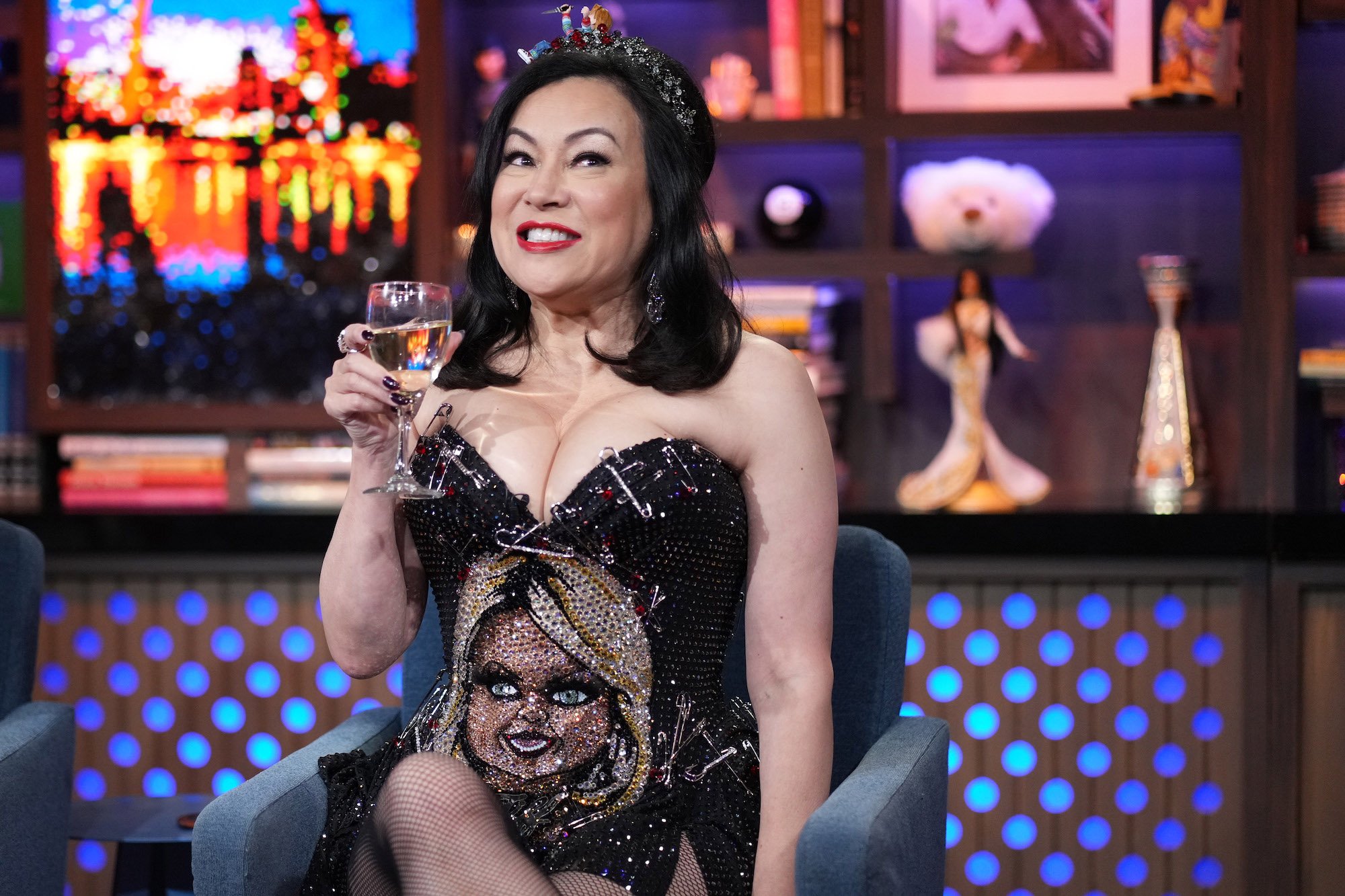 Chucky star Jennifer Tilly smiles and holds a glass of wine