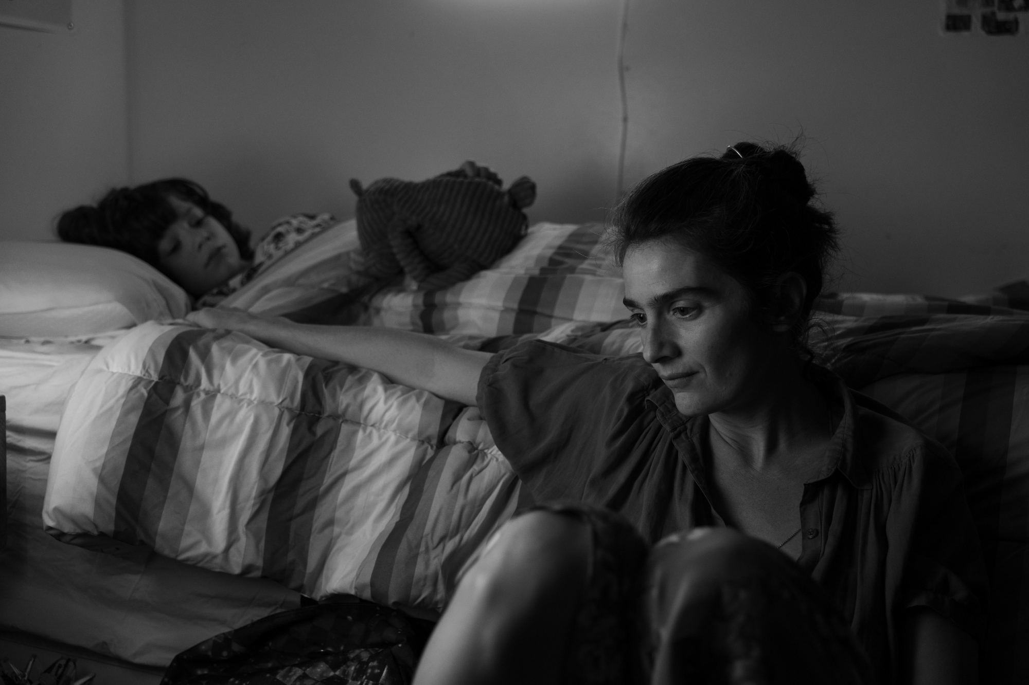 'C'mon C'mon' actors Woody Norman as Jesse and Gaby Hoffmann as Viv with Jesse in his bed and Viv sitting next to the bed with her arm on the bed