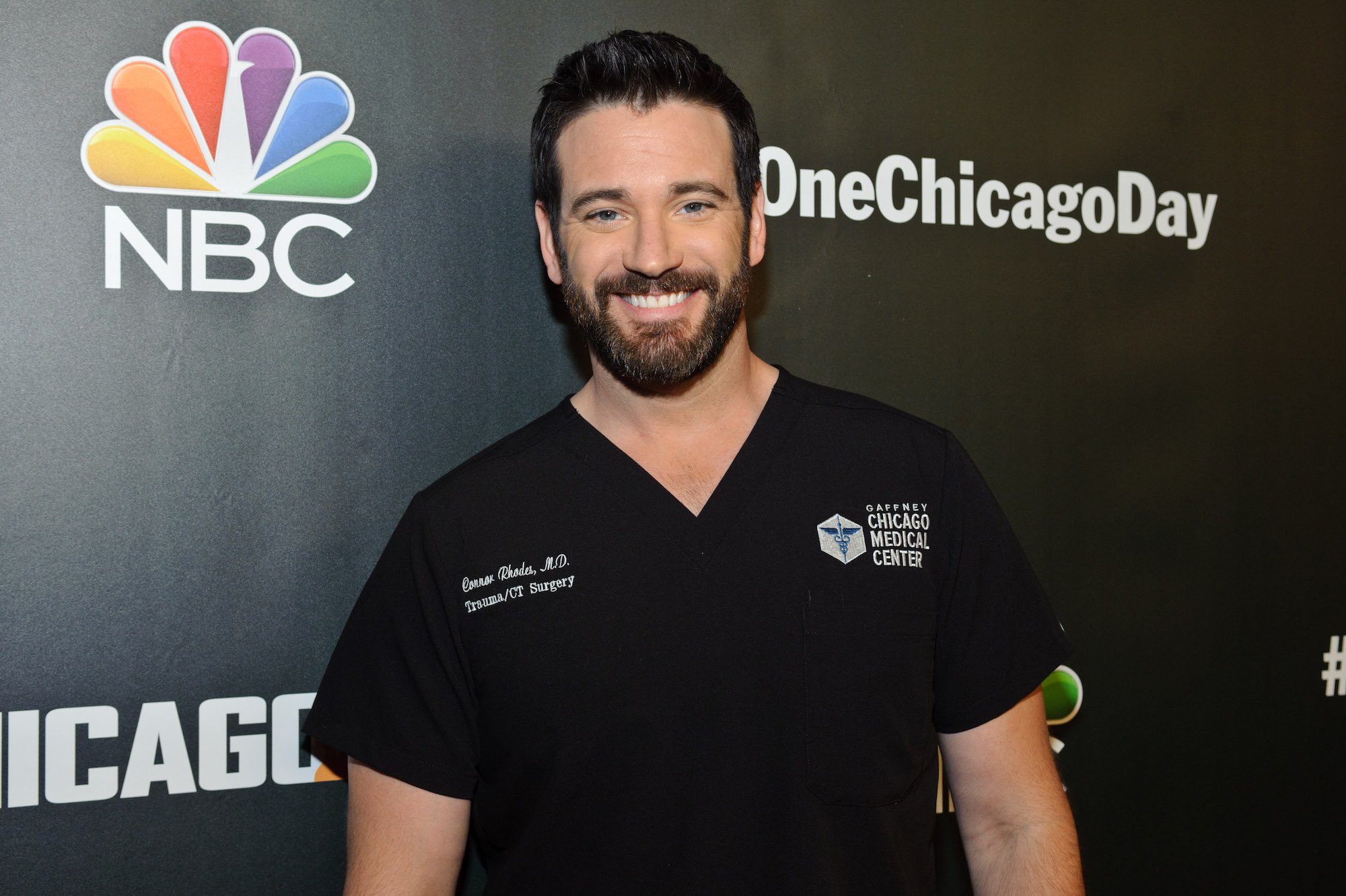 Colin Donnell dressed in black scrubs at the 2018 Chicago Press Day.