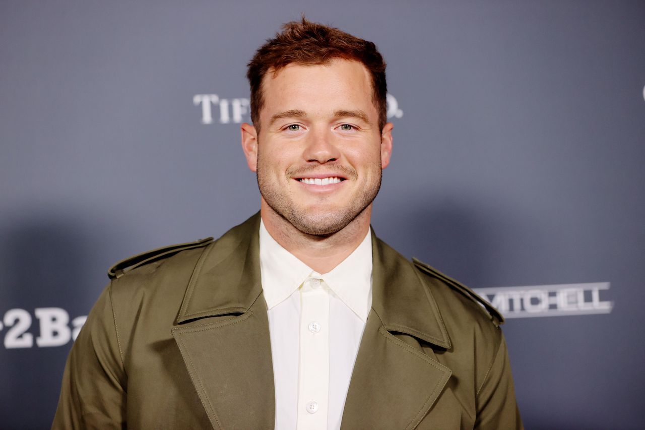 Colton Underwood smiles while standing on the red carpet.