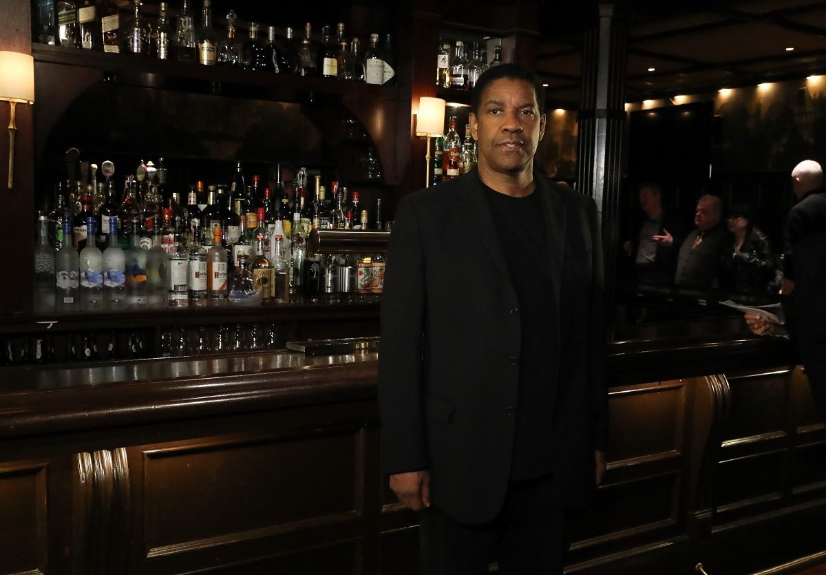Denzel Washington posing in a black suit