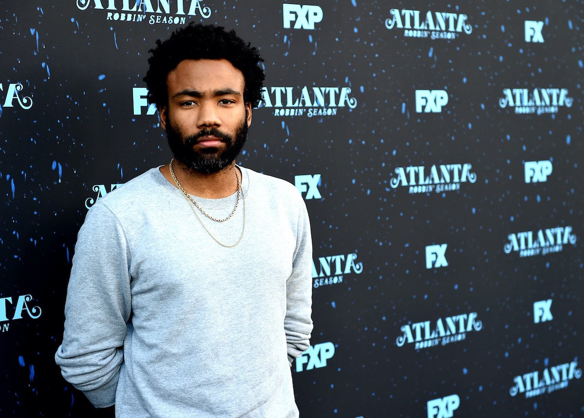 Donald Glover wears a blue shirt and gold chains at an FX event for his show 'Atlanta'