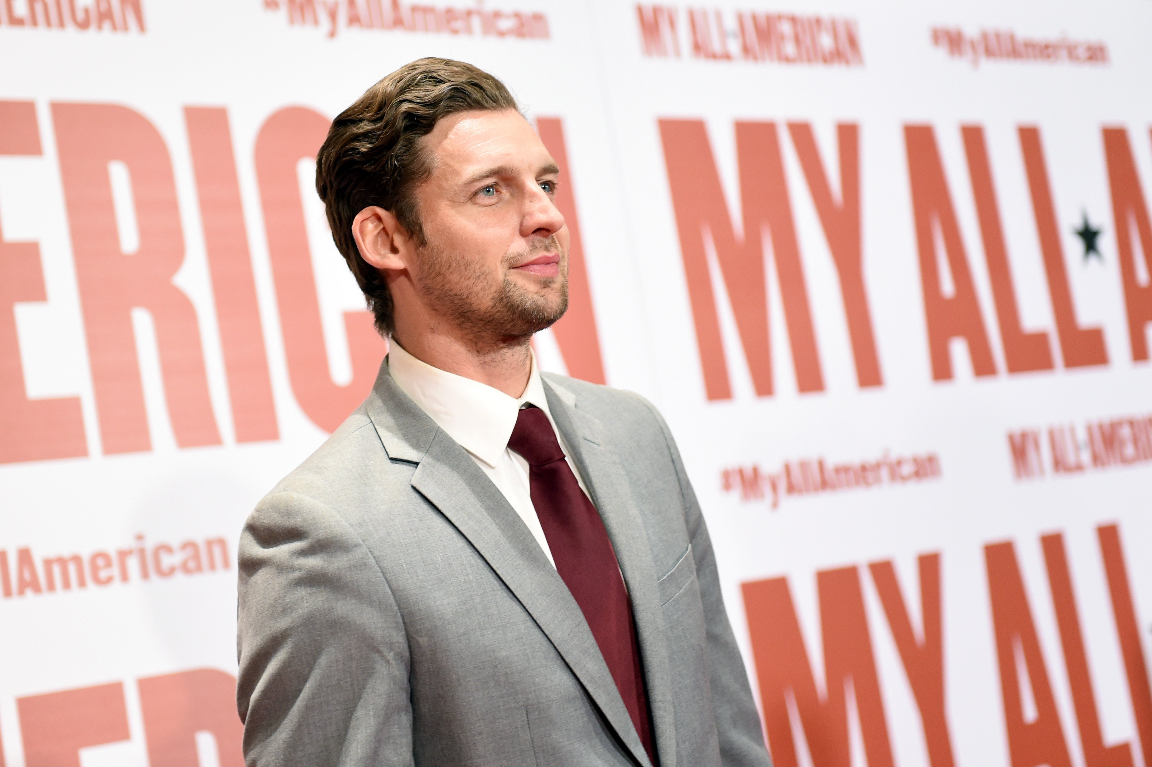'The Young and the Restless' actor Donny Boaz wearing a grey suit, white shirt, and burgundy tie.