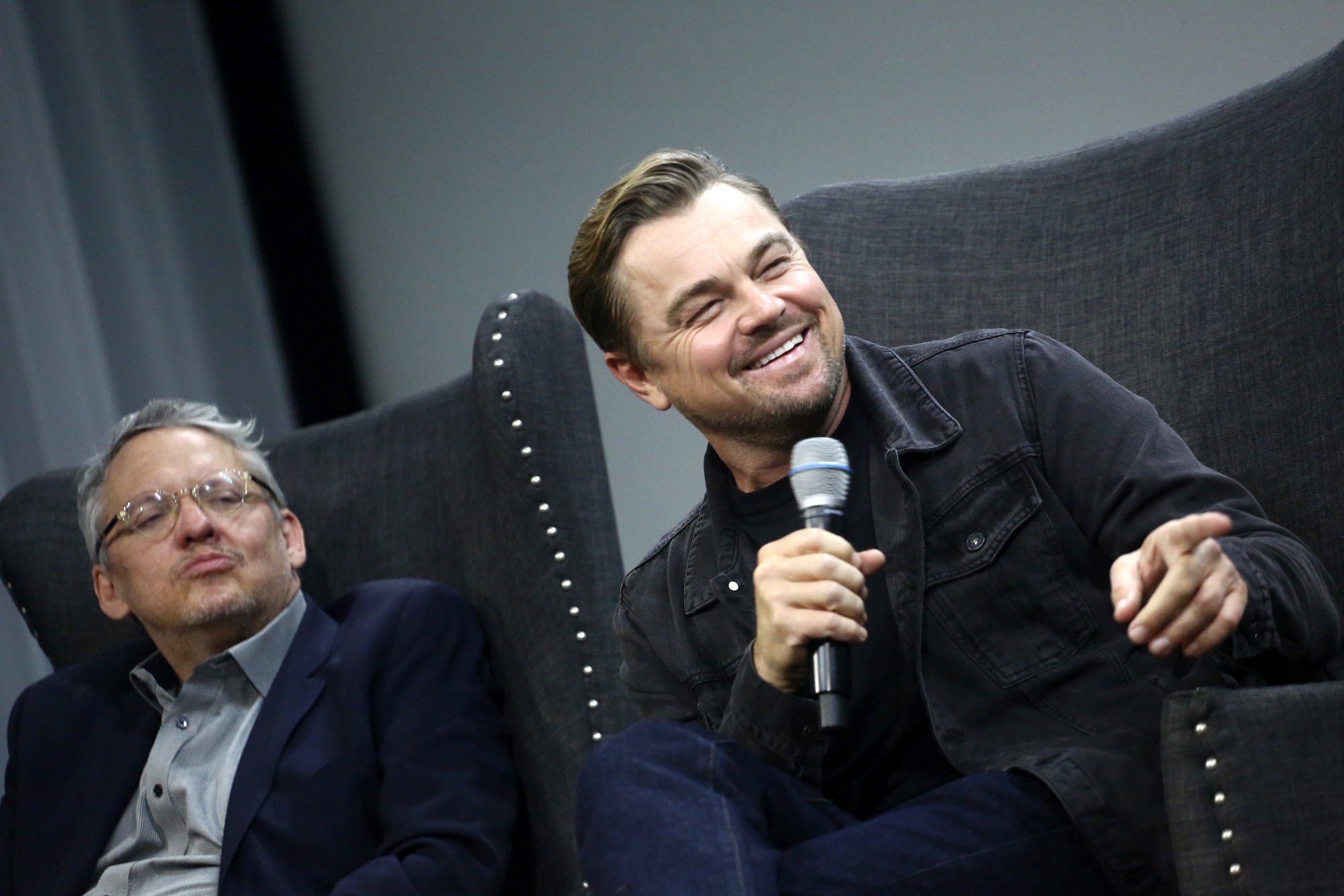 'Don't Look Up' Leonardo DiCaprio and Adam McKay sitting in chairs with a mic in front of a theater screen