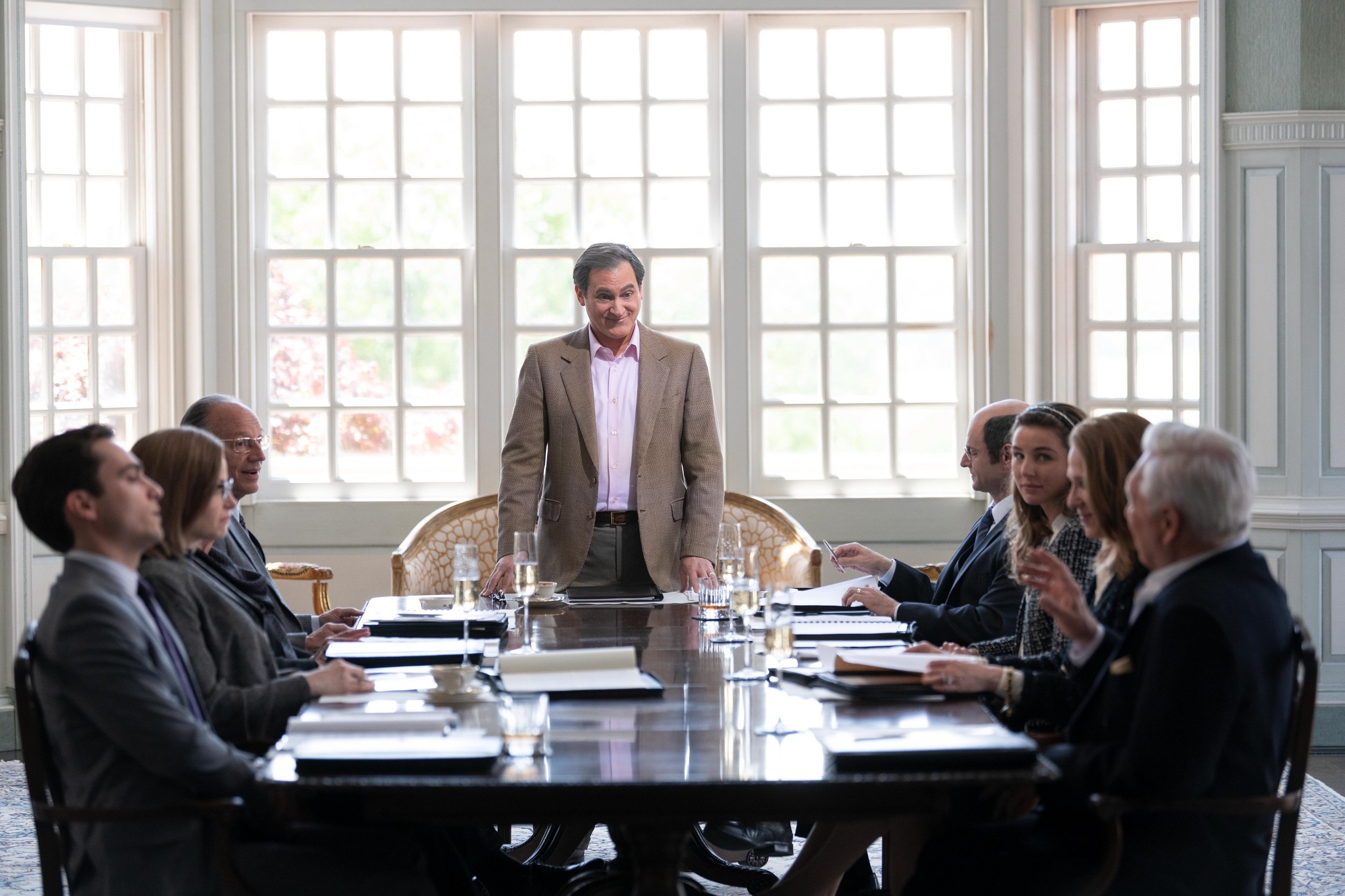 'Dopesick' cast member Michael Stuhlbarg standing in front of a table of people as Richard Sackler