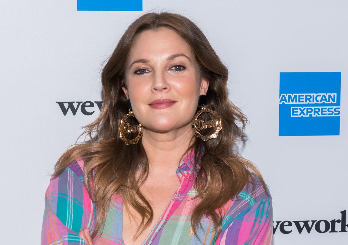 Drew Barrymore in a plaid shirt wearing 'Drew' earrings