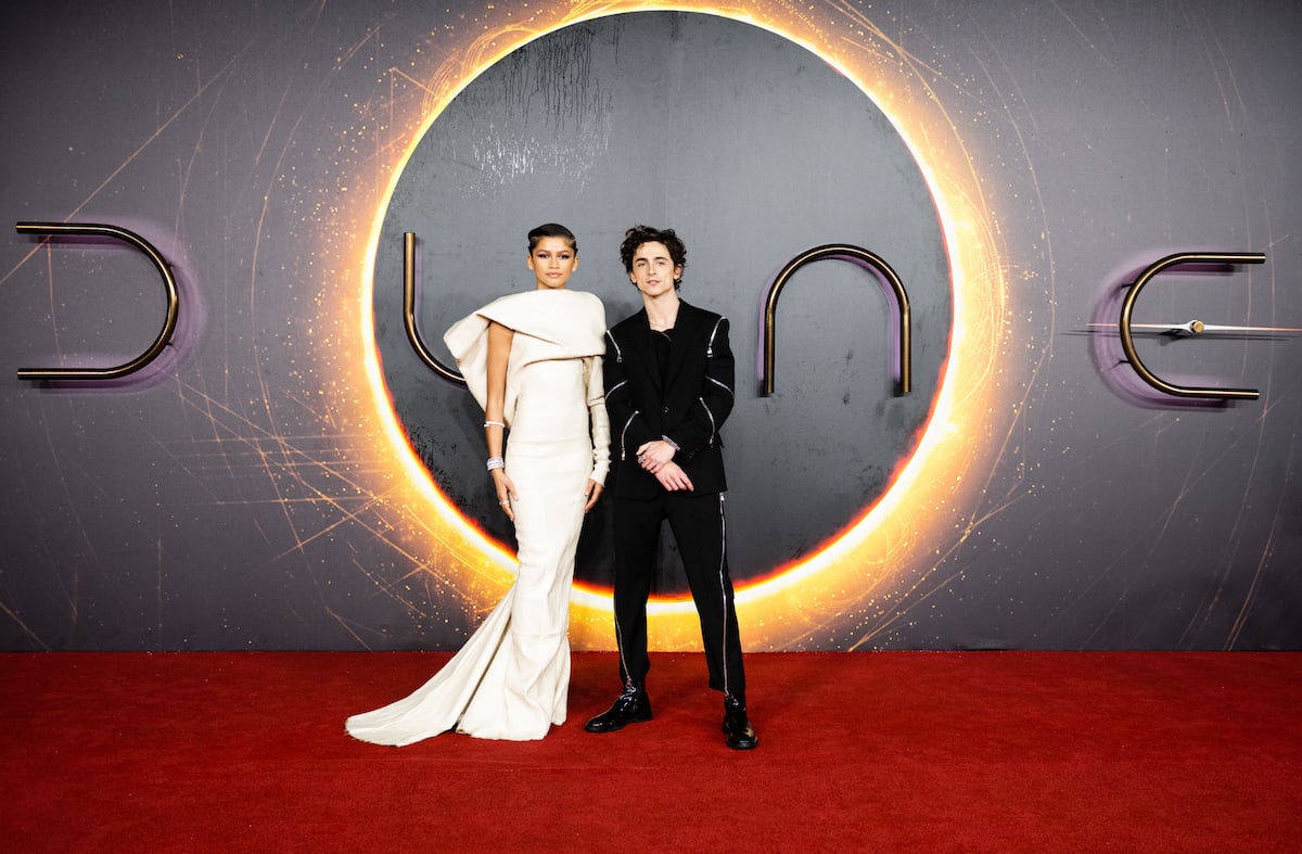 (L-R) Zendaya and Timothée Chalamet smiling in front of a dark background and the 'Dune' logo