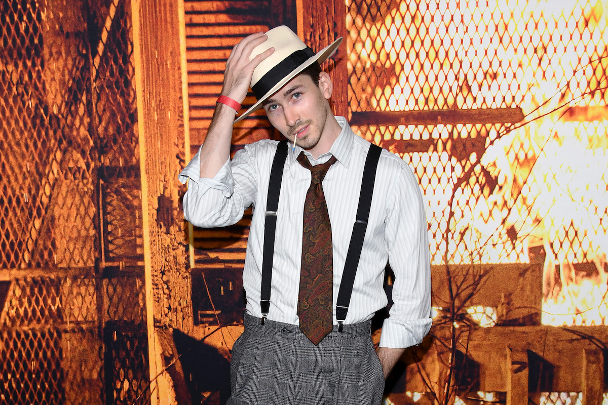 Dylan Arnold poses in a hat and suspenders at a costume party.