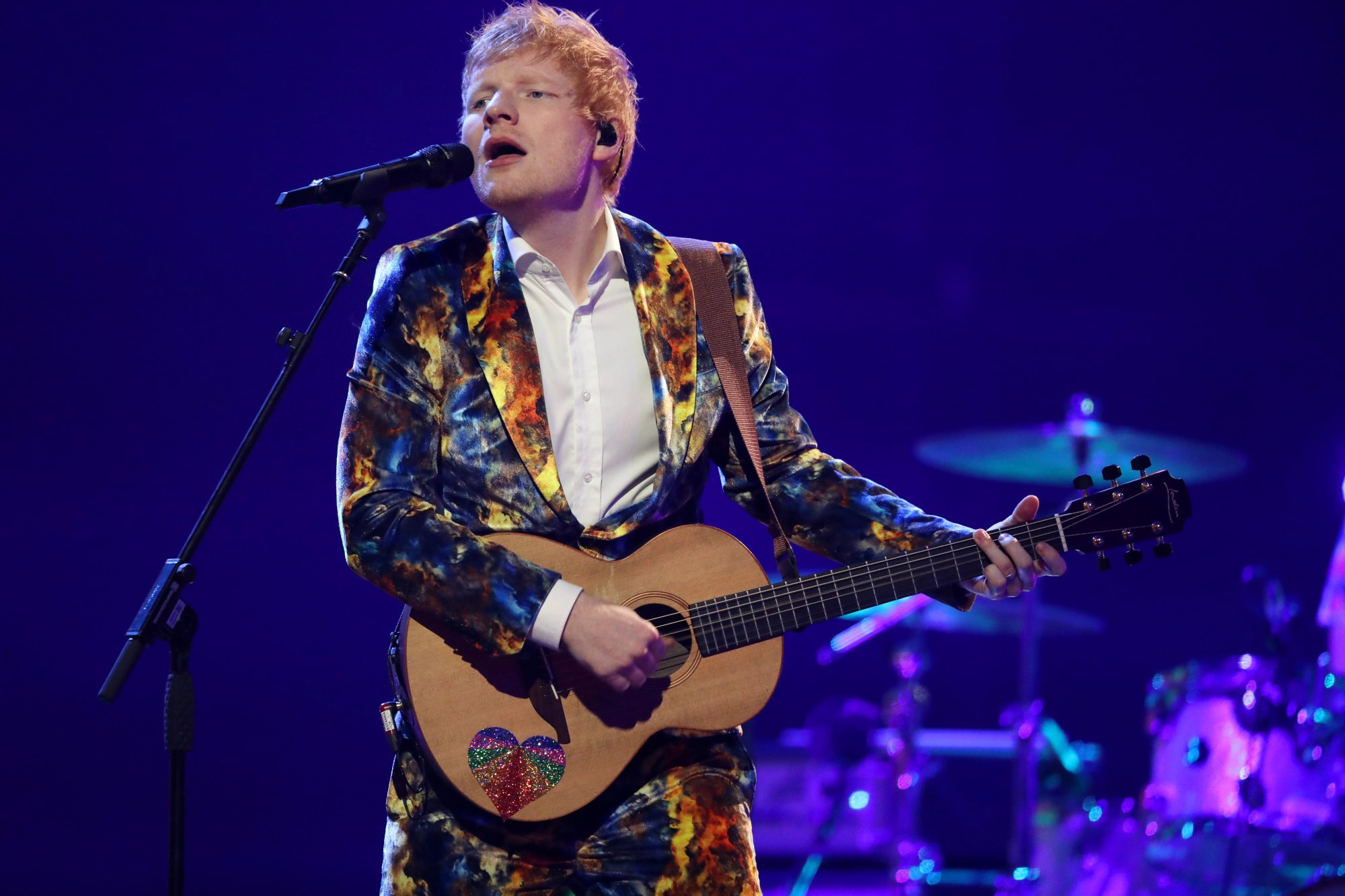 Ed Sheeran playing guitar and singing. He'll be featured in a new 'Pokémon GO' event in November 2021.