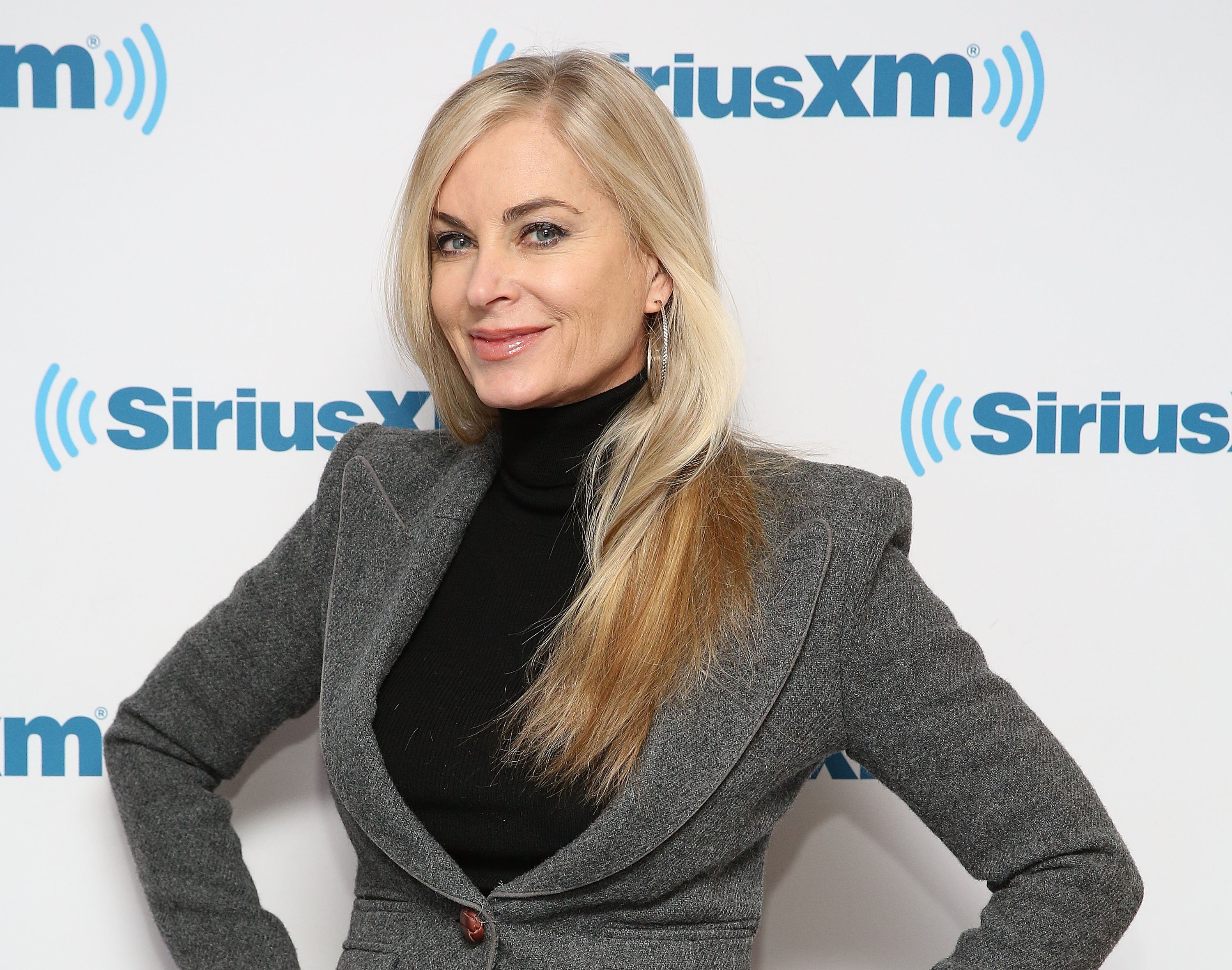 'The Young and the Restless' actor Eileen Davidson wearing a grey jacket and black shirt, stands in front of a siriusxm backdrop.