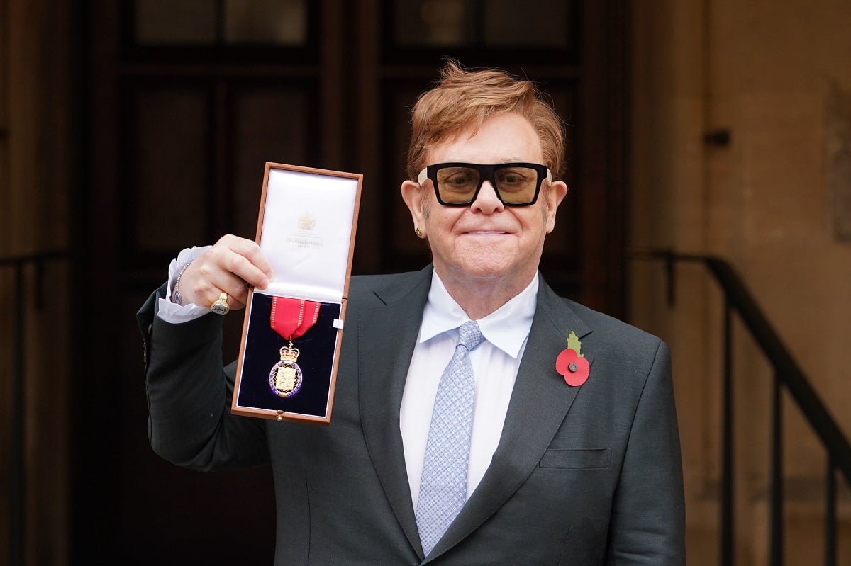 Elton John posing with an award