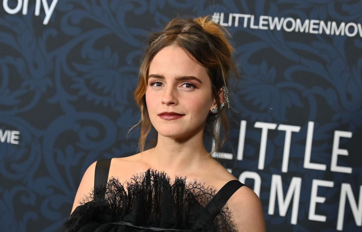 Emma Watson smiling in front of a black background