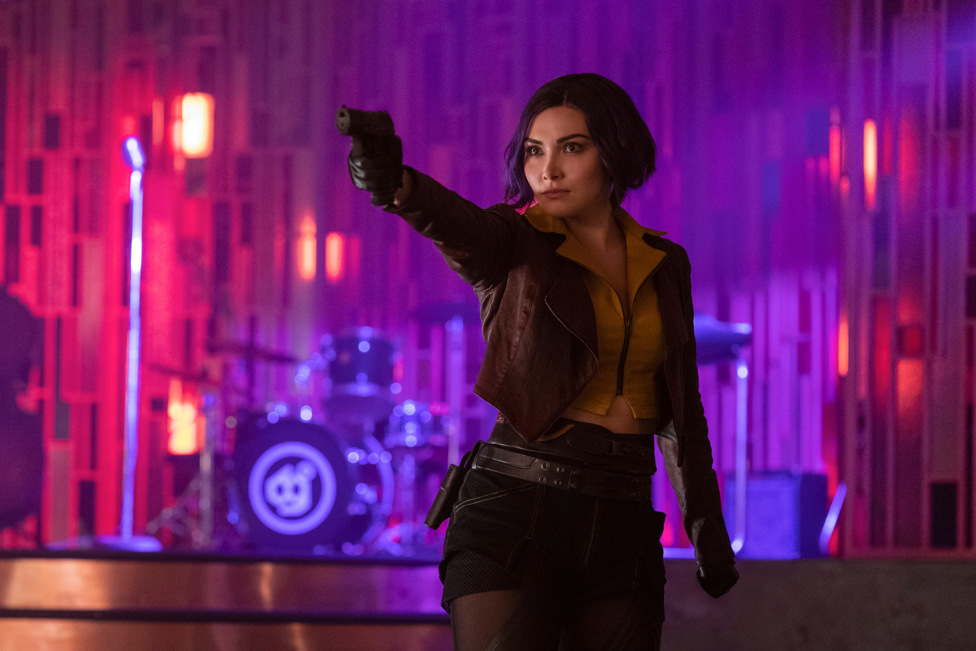 Daniella Pineda as Faye Valentine in Netflix's live-action 'Cowboy Bebop.' She's holding up a gun.