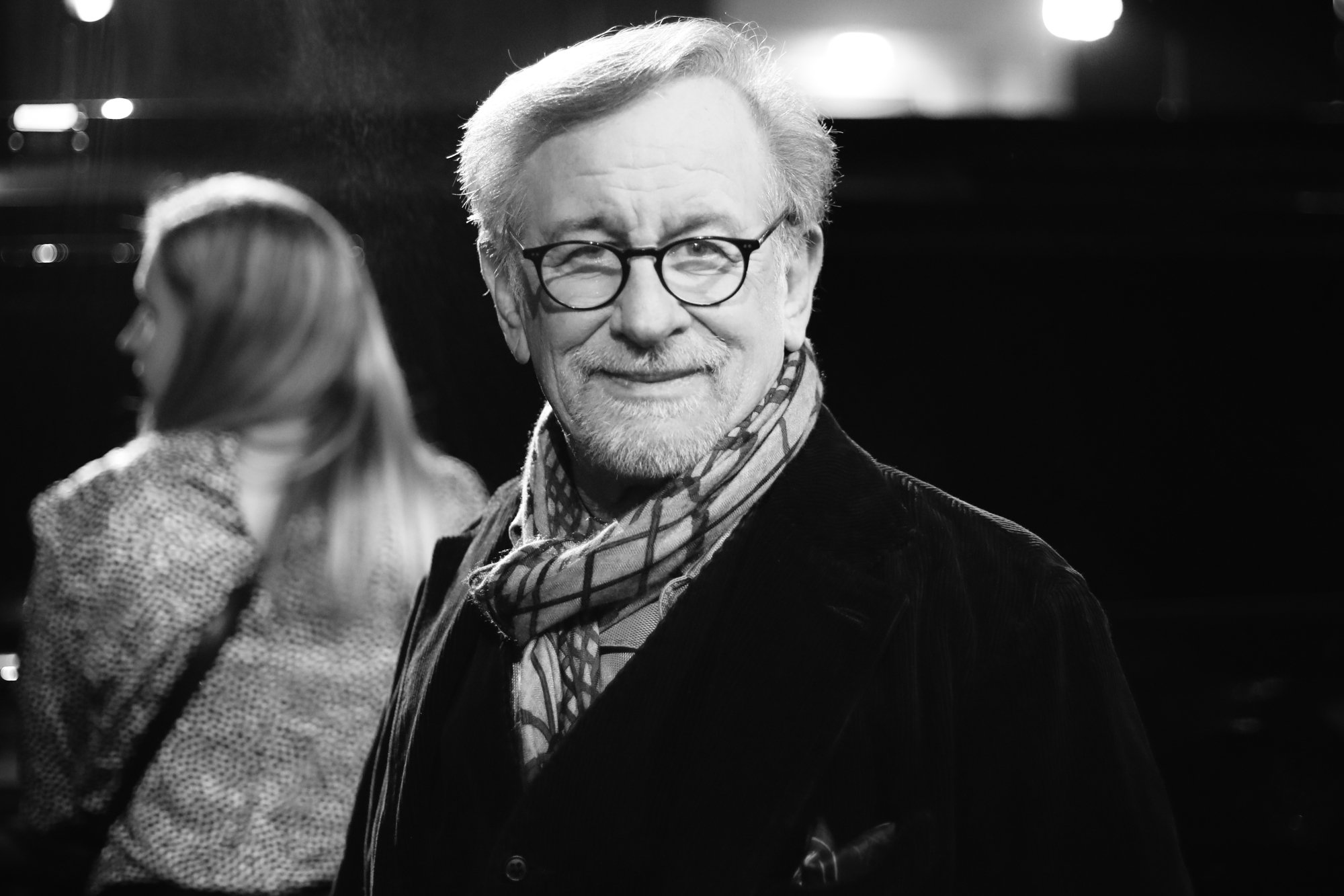 Featured image about Steven Spielberg Universal Studios Lot wearing a black coat and a scarf in black-and-white