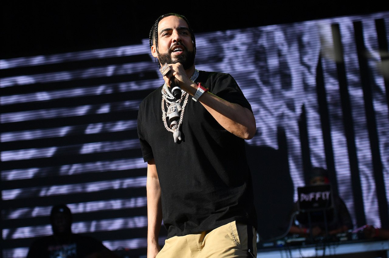 French Montana stands on stage holding a microphone.