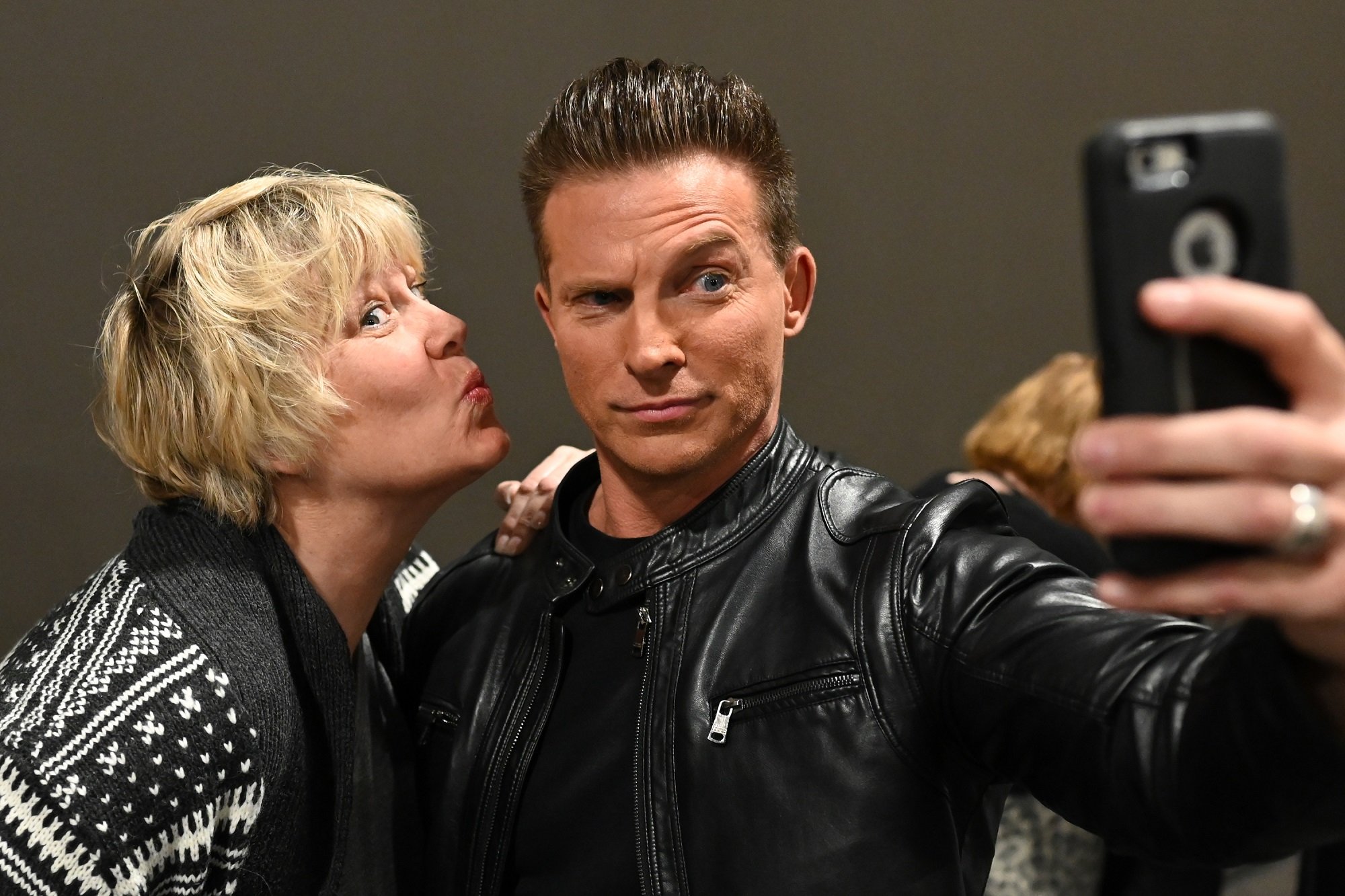 General Hospital star Steve Burton, posing in a black leather jacket with a fan