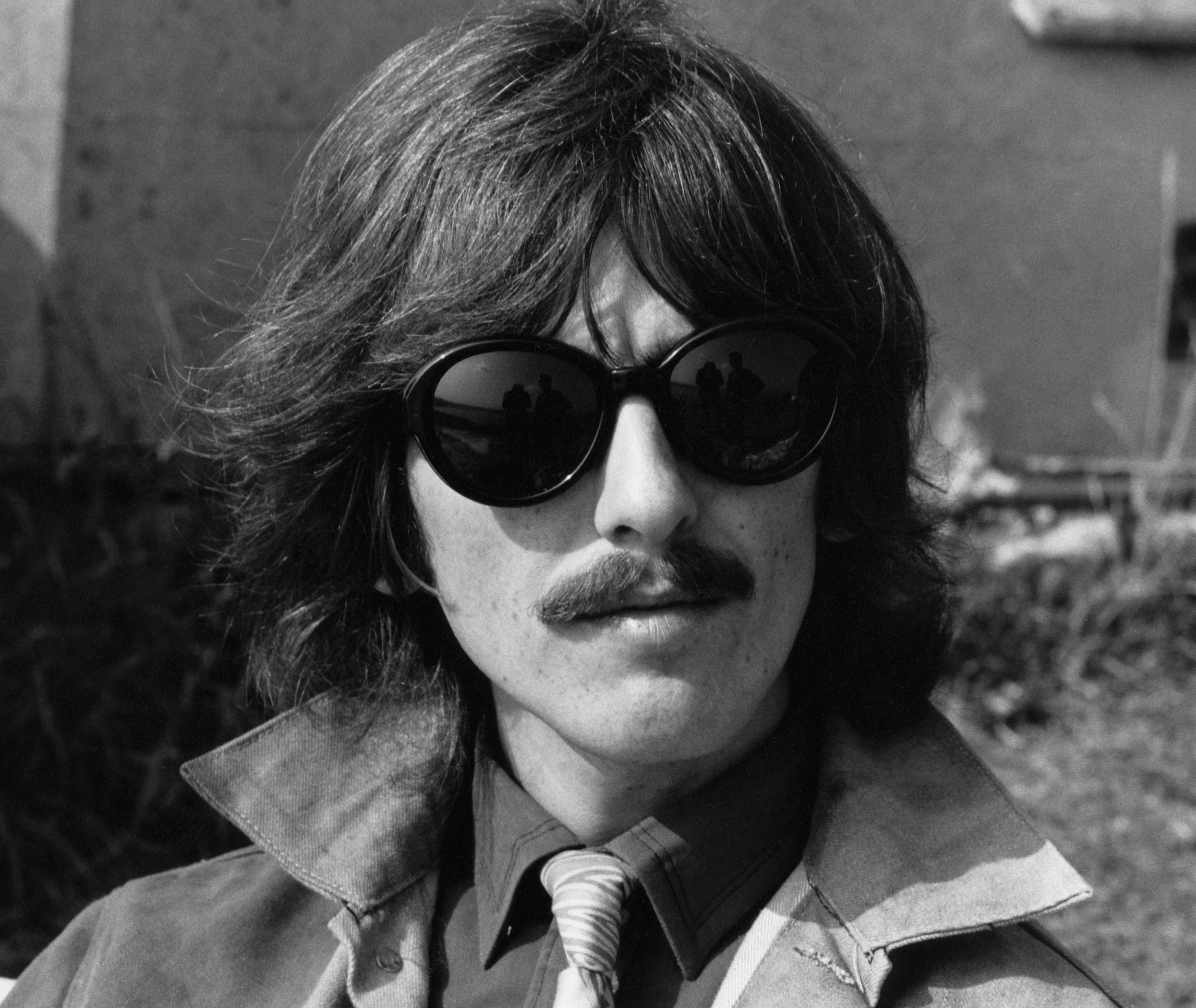 George Harrison of The Beatles, wearing sunglasses and a denim jacket, takes part in filming of the television musical film 'Magical Mystery Tour' in Plymouth, Devon on September 12, 1967.