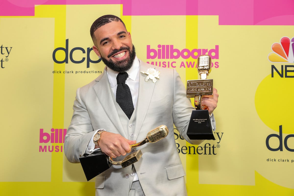 Drake poses on the red carpet with awards