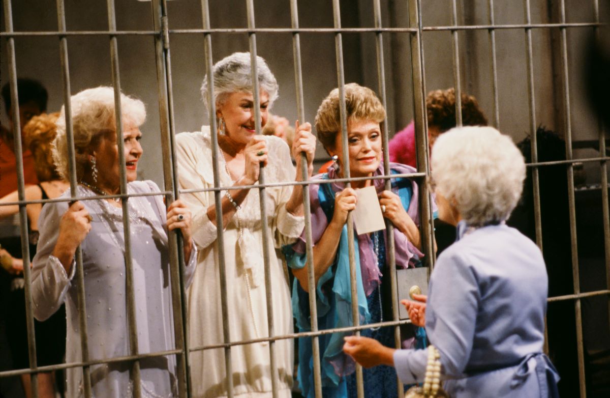 (L-R) Betty White, Bea Arthur, and Rue McClanahan behind bars, Estelle Getty on the other side facing them