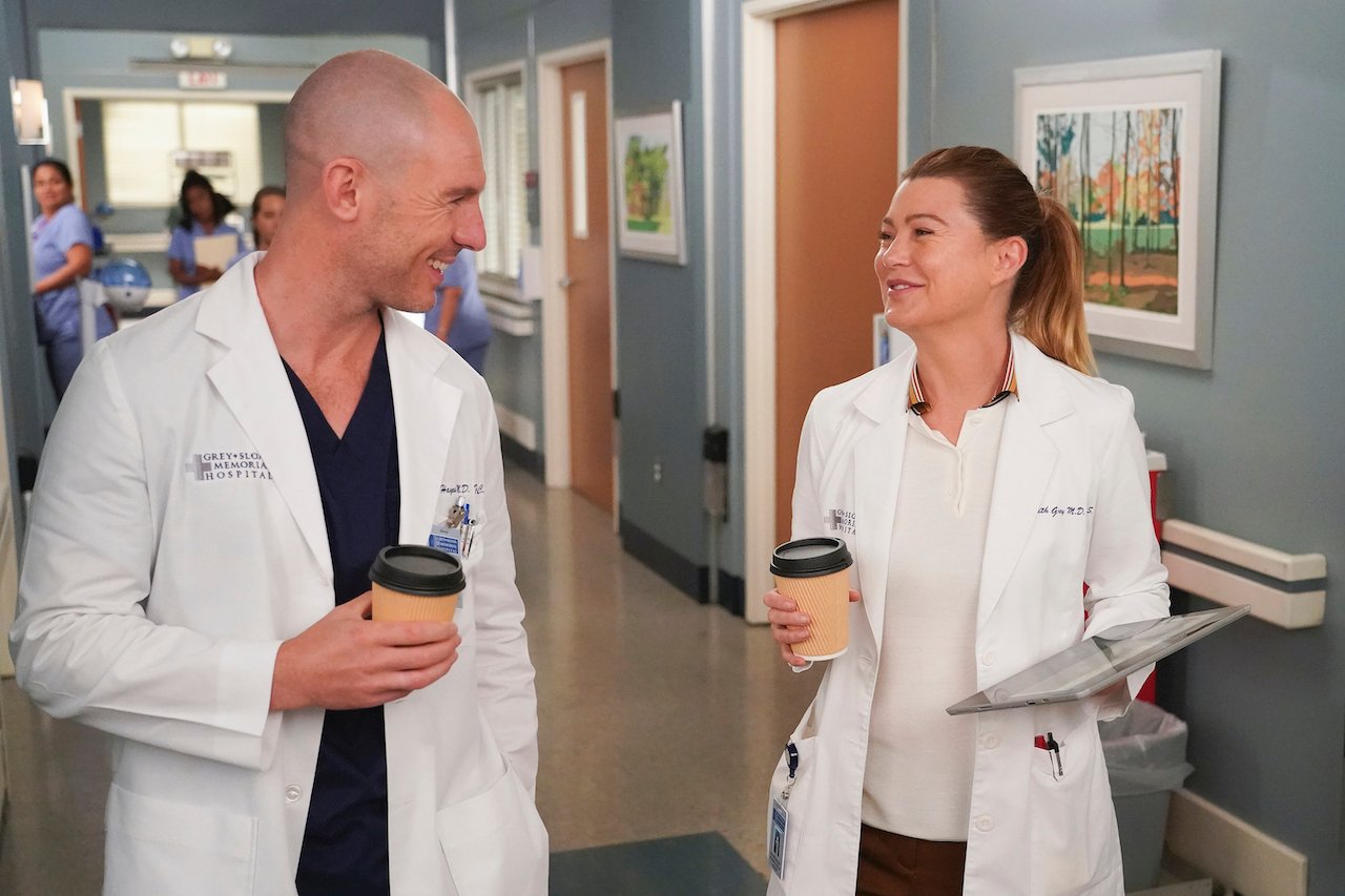 Richard Flood as Cormac Hayes and Ellen Pompeo as Meredith Grey walk in a hallway on 'Grey's Anatomy'