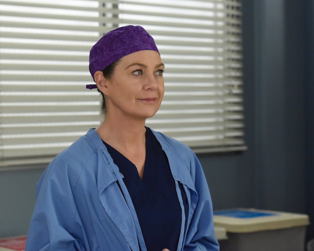 Ellen Pompeo as Meredith Grey stands in scrubs on 'Grey's Anatomy'