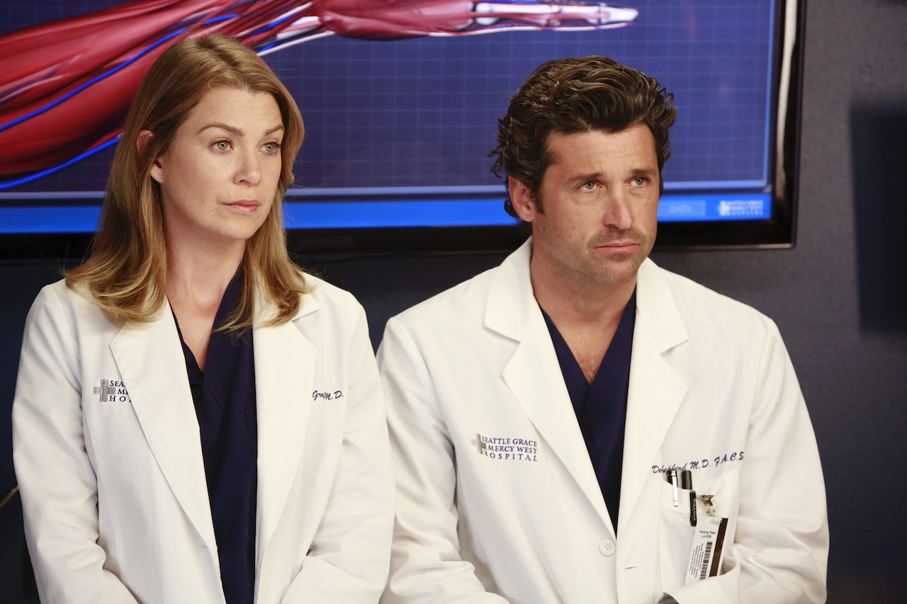 Ellen Pompeo as Meredith and Patrick Dempsey as Derek on 'Grey's Anatomy' sit next to each other in lab coats.