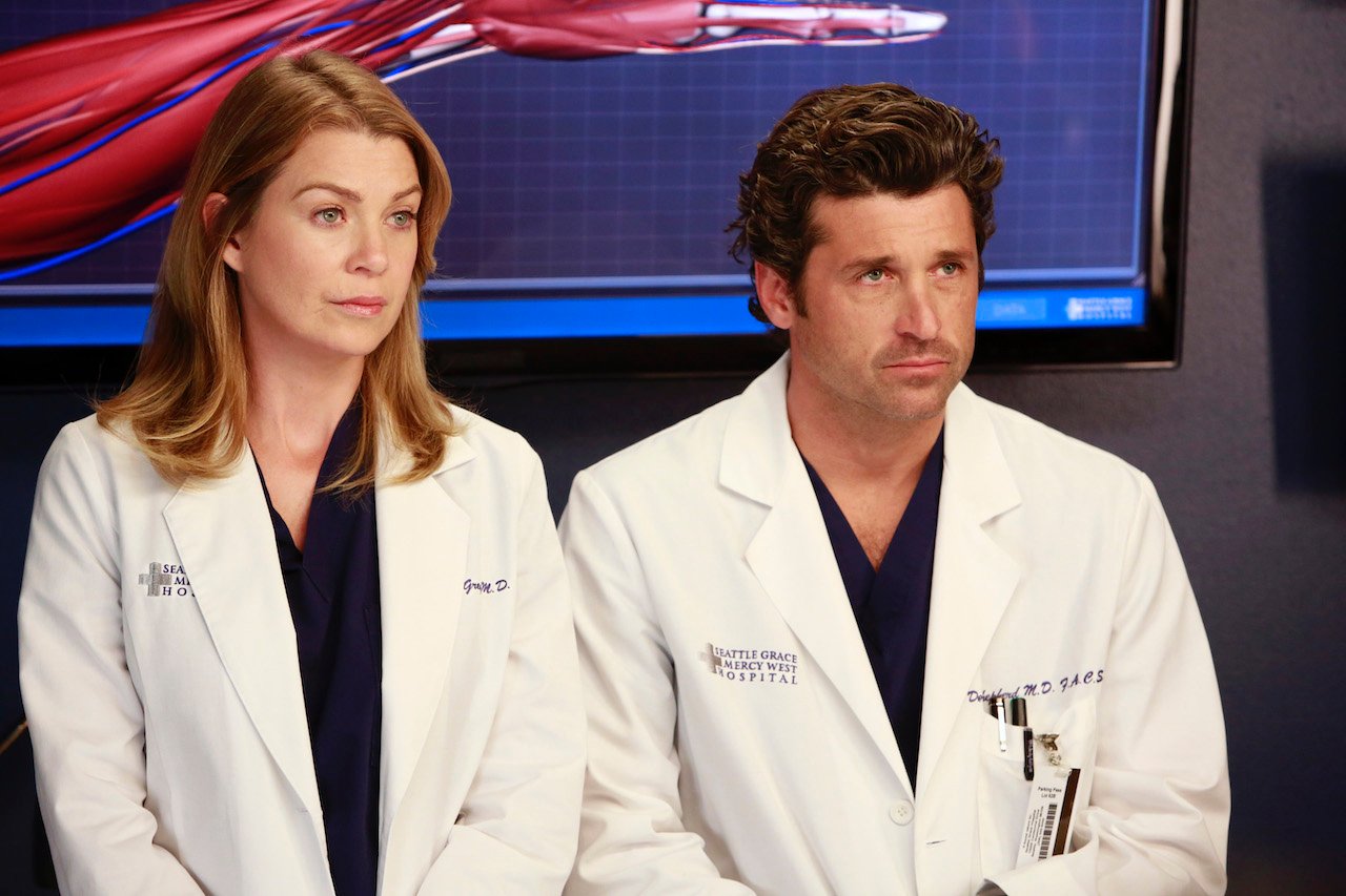 Ellen Pompeo as Meredith and Patrick Dempsey as Derek on 'Grey's Anatomy' sit next to each other in lab coats.