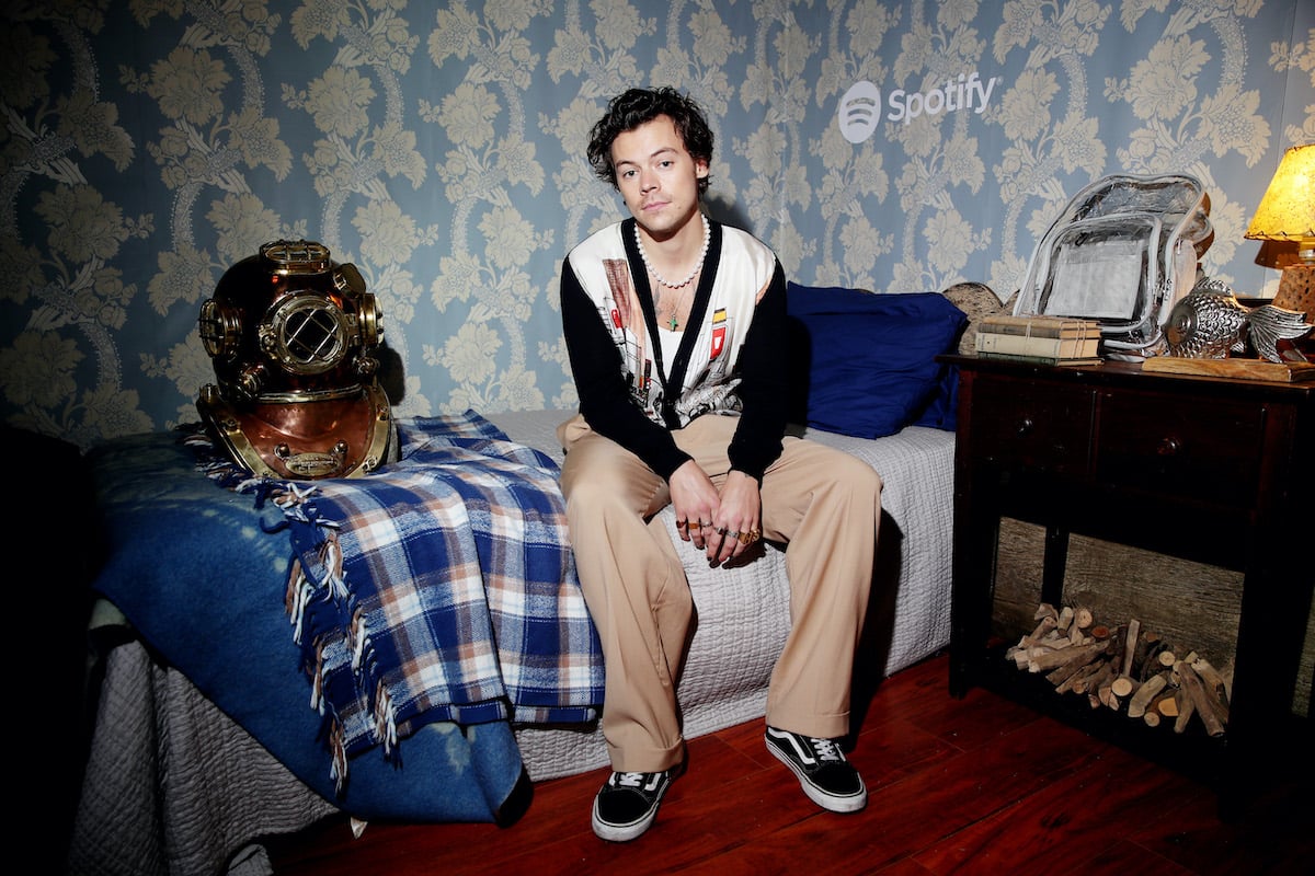 Harry Styles is featured seated on a bed for a Spotify promo for a private listening session of his 2019 album