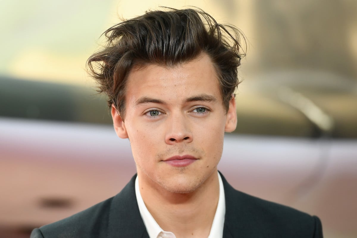 Harry Styles smiles for the camera at an event.